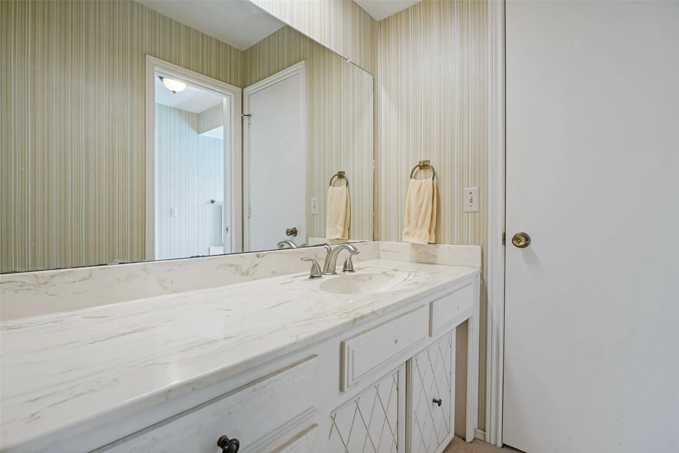 Vanity featuring a stone-finish countertop, integrated sink, and dual-handle faucet