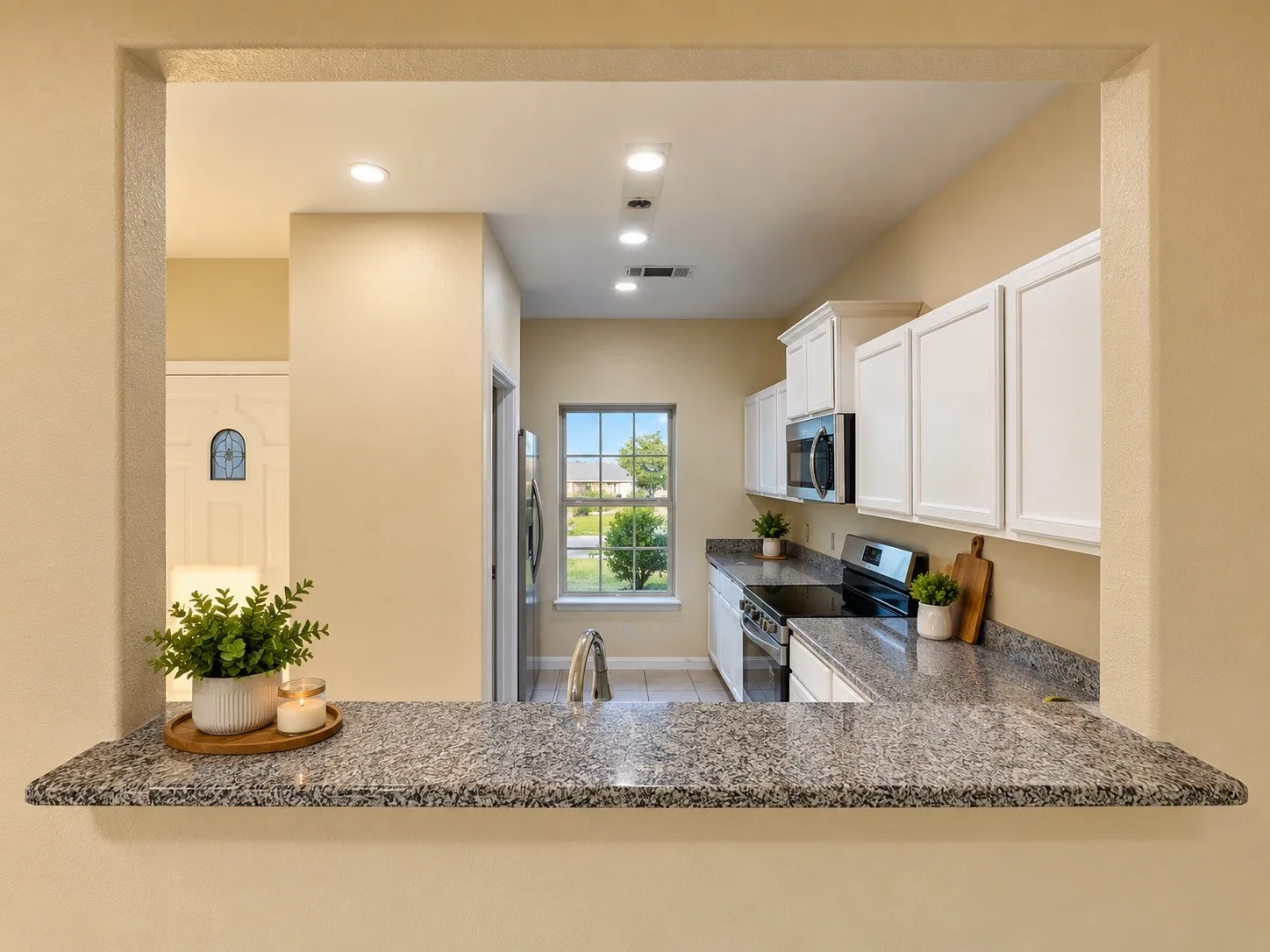 Kitchen pass-through featuring a granite countertop