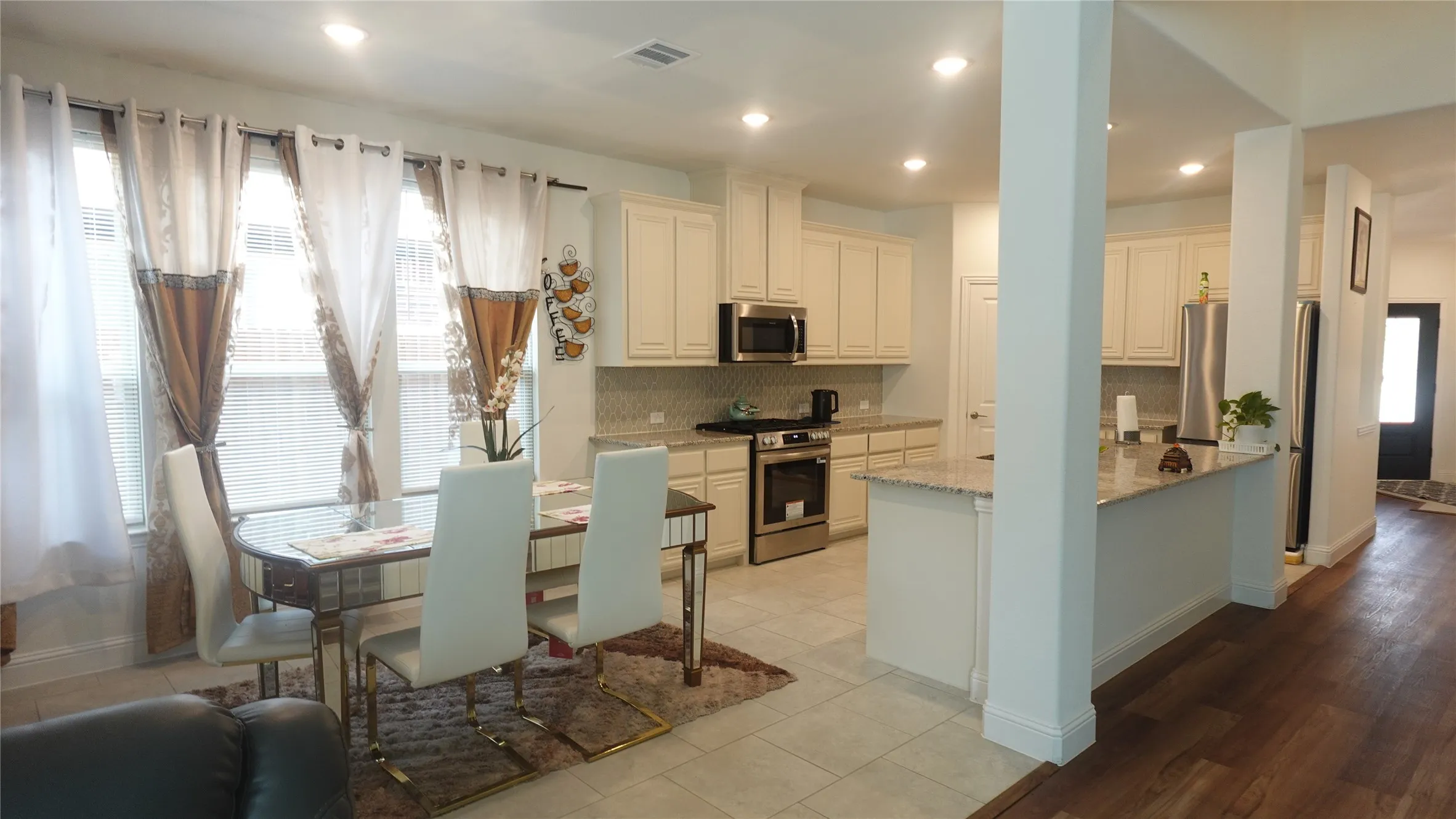 Kitchen featuring stainless steel appliances, light cabinetry, and granite countertops