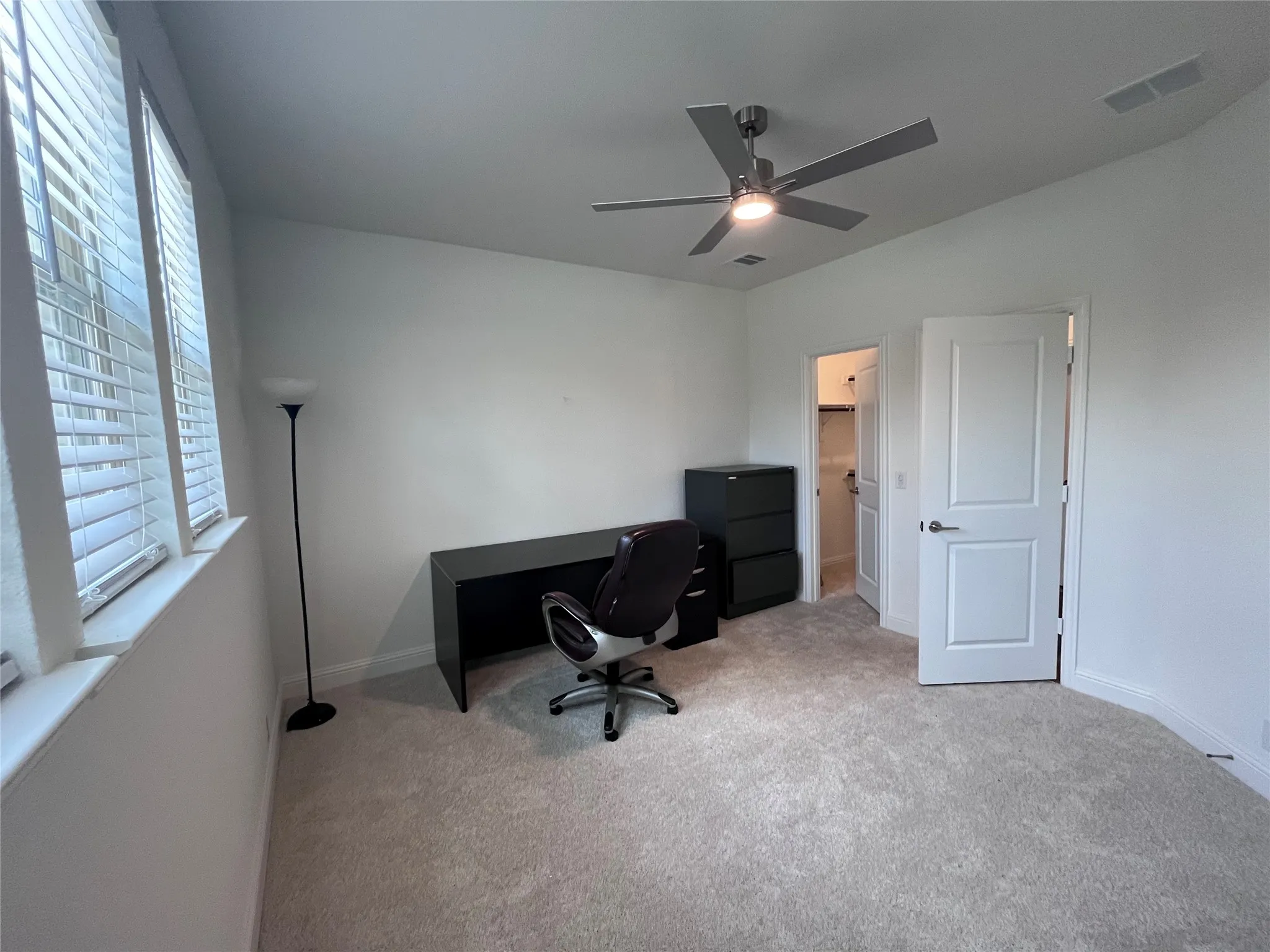 Plush carpeting, recessed lighting, and a contemporary ceiling fan
