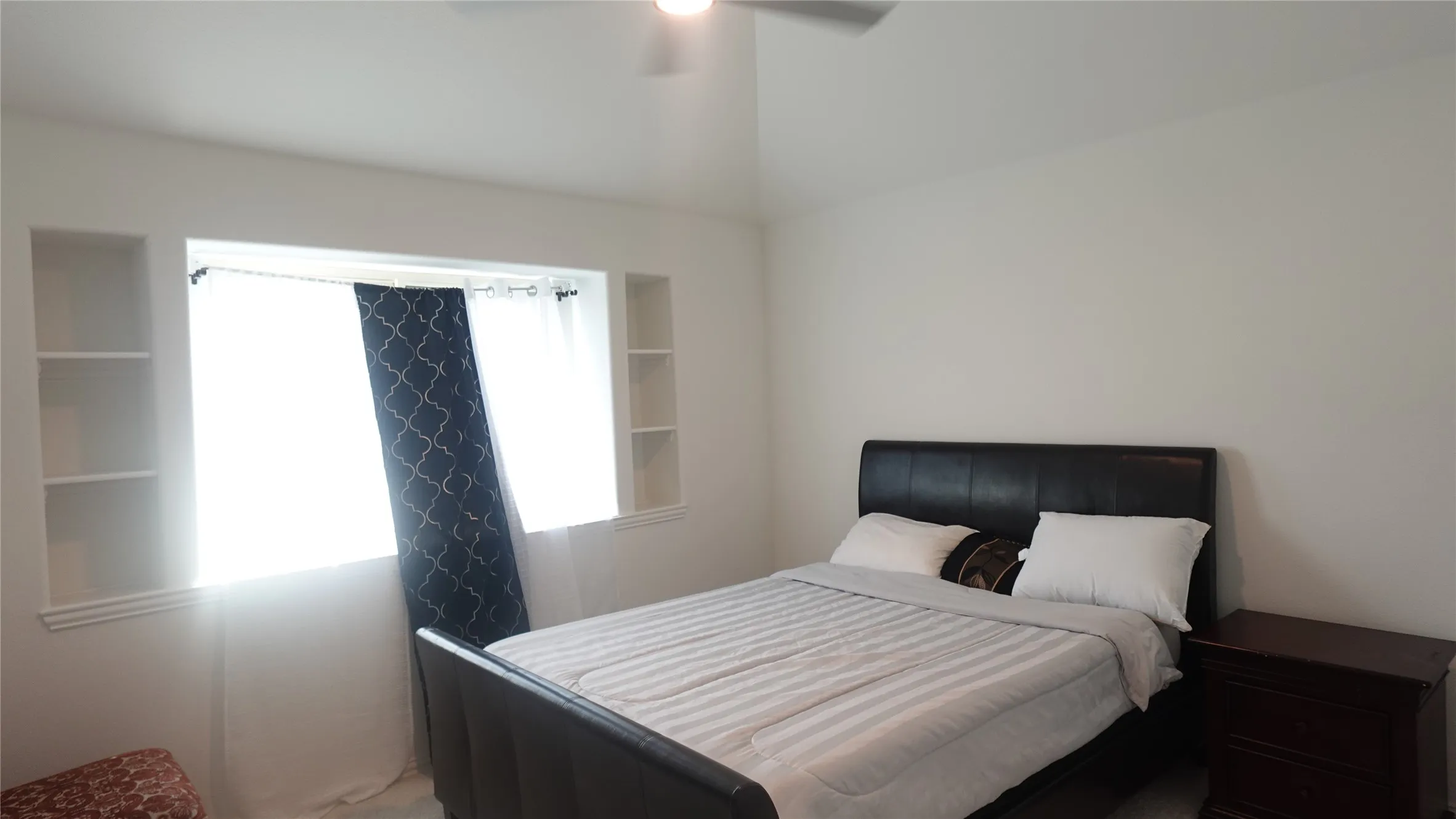 Bedroom 5 with recessed window with built-in shelving, vaulted ceiling, and ceiling fan