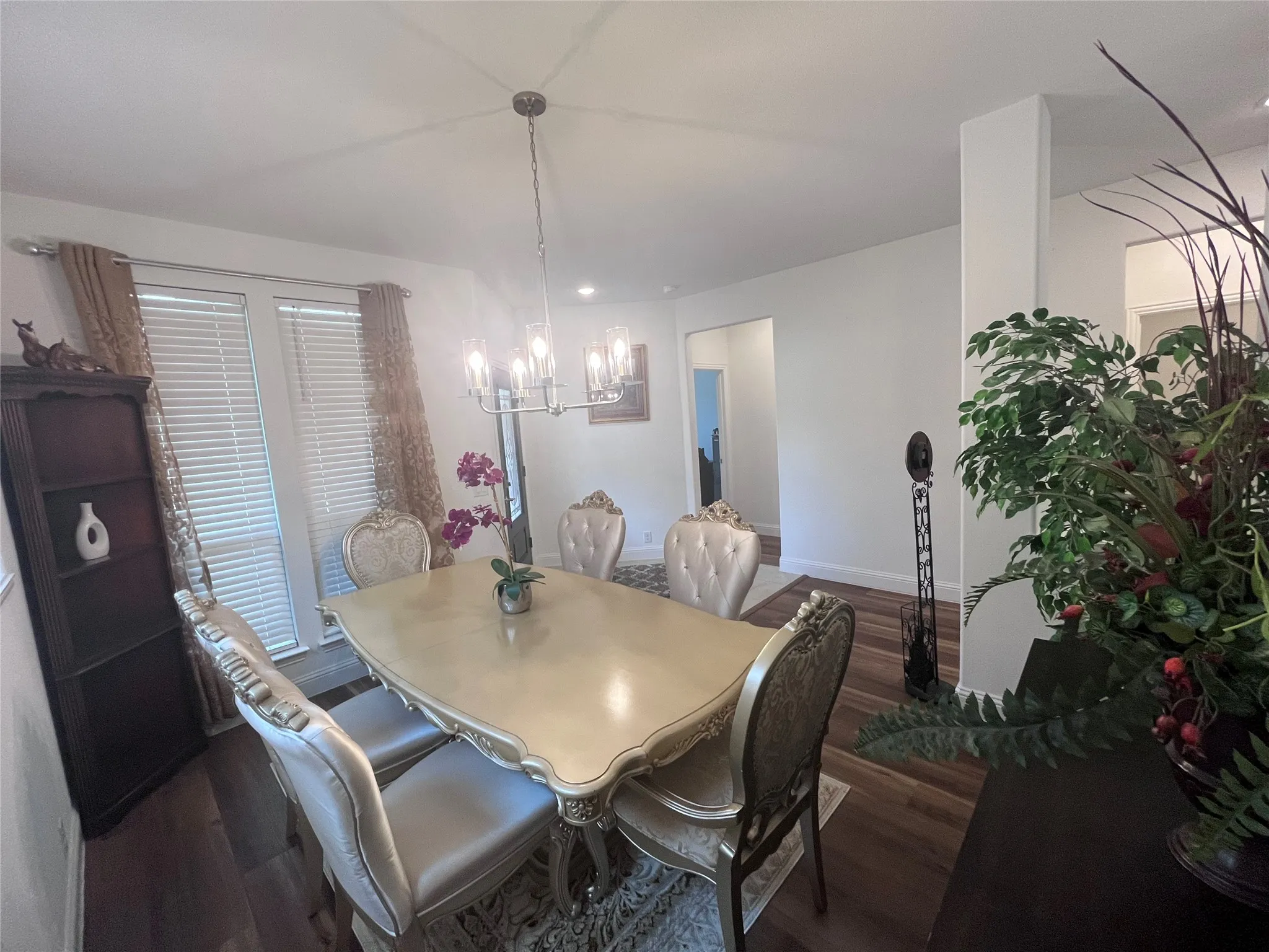 Open concept dining space with wood-finish flooring, recessed lighting, and a modern chandelier