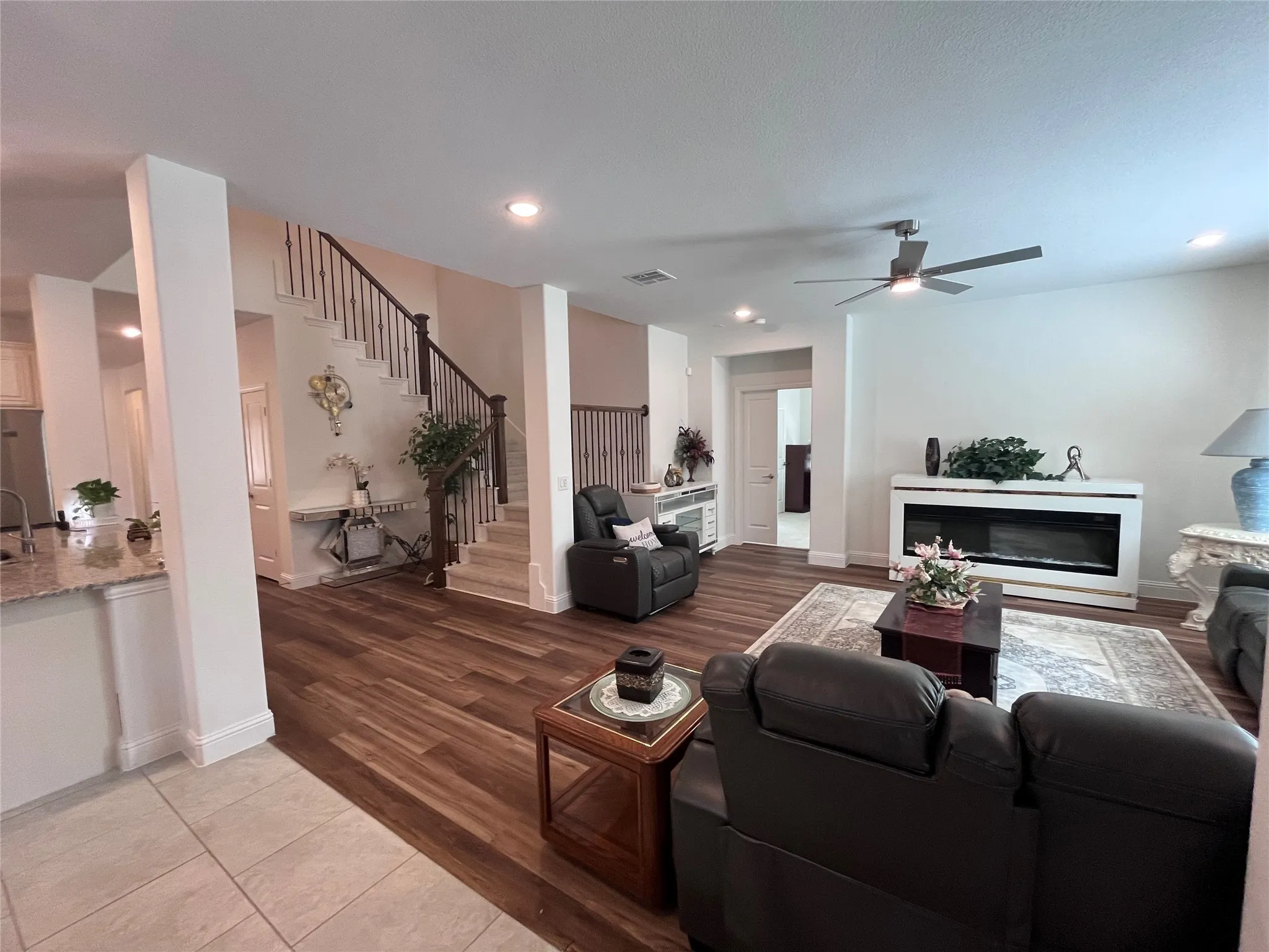 Living area featuring wood-finish flooring, a built-in fireplace, a ceiling fan, and recessed lighting