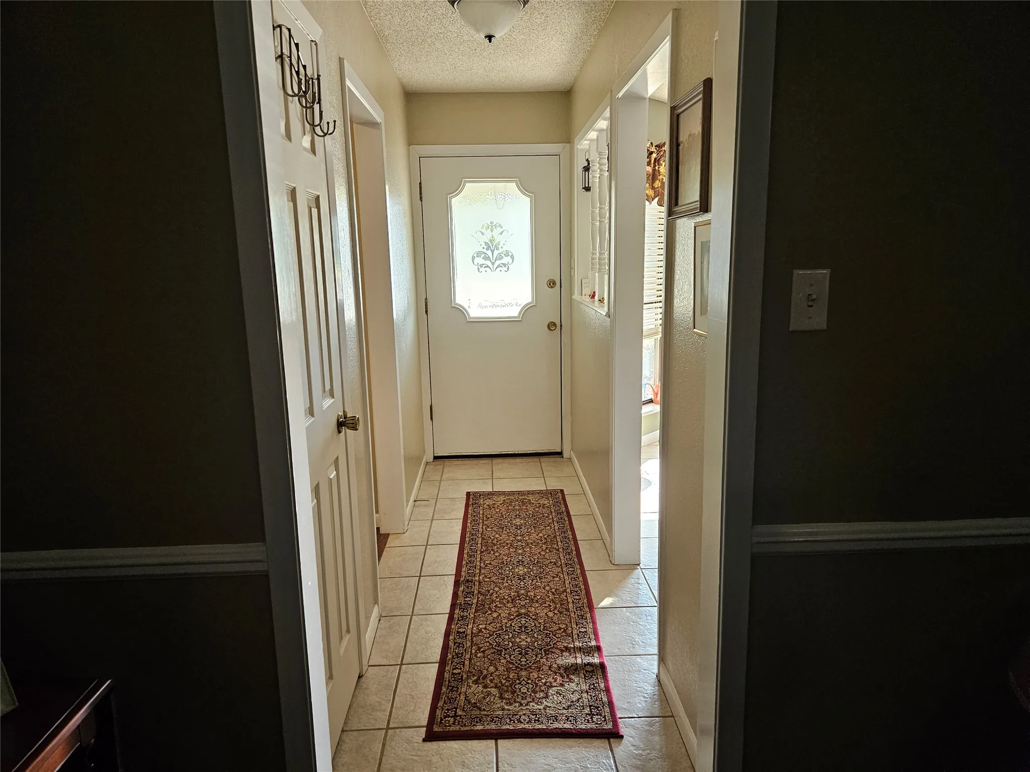 Foyer featuring a decorative glass-paneled entry door, recessed ceiling lighting, and light-toned floor tiling