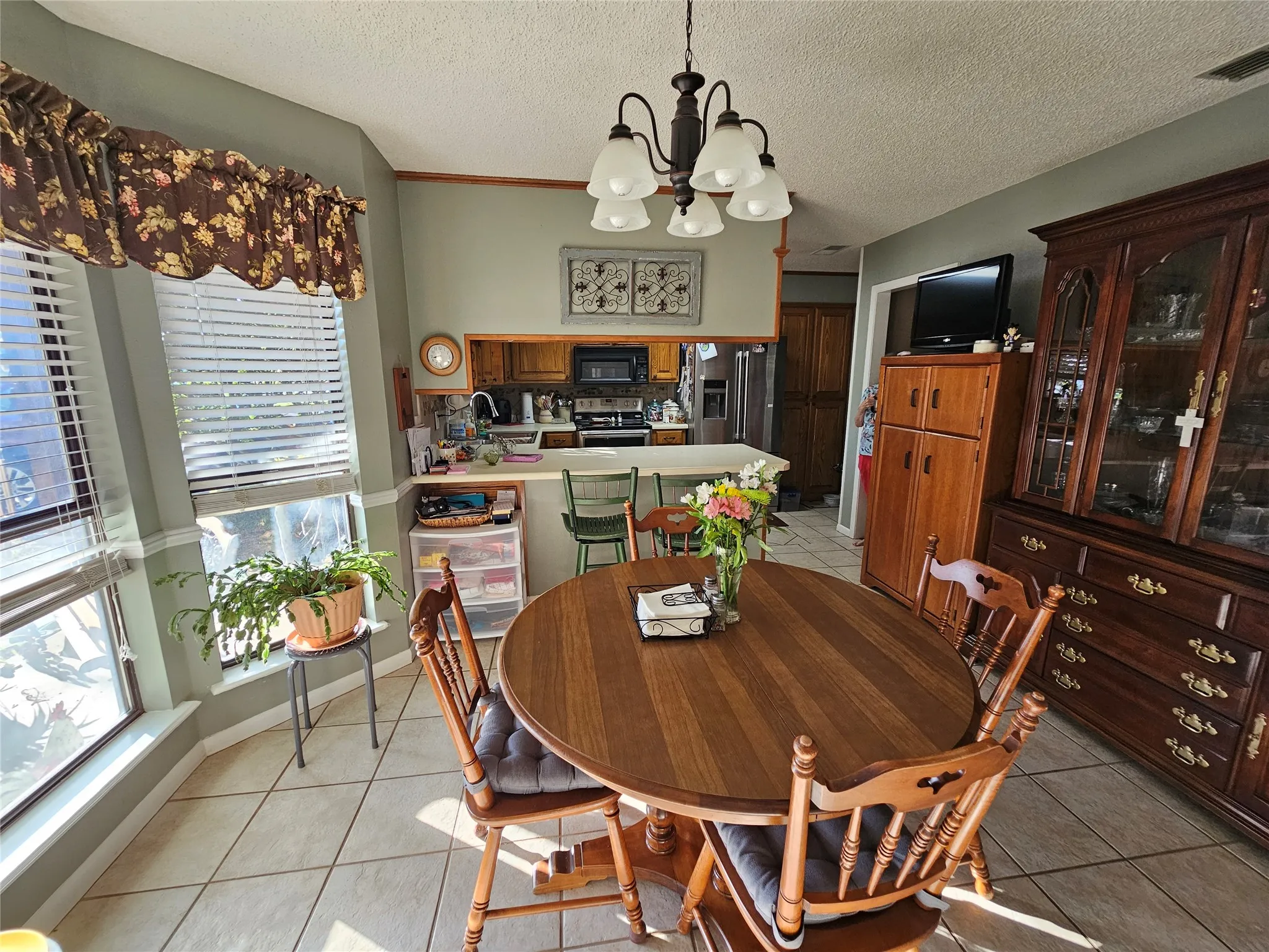 Kitchen and dining area featuring a breakfast bar, recessed lighting, and tile flooring