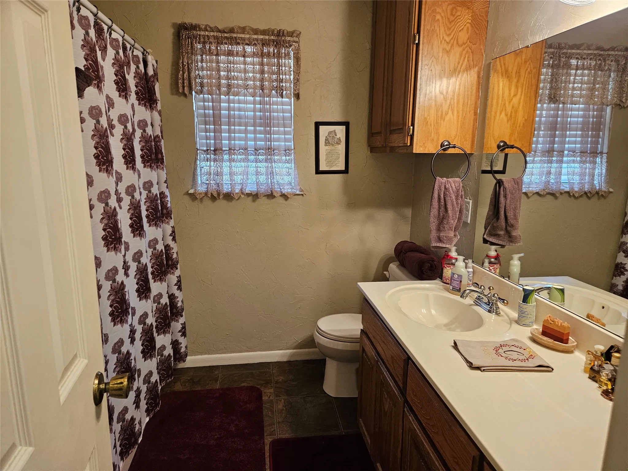 Wood-finish vanity with a white countertop and integrated sink