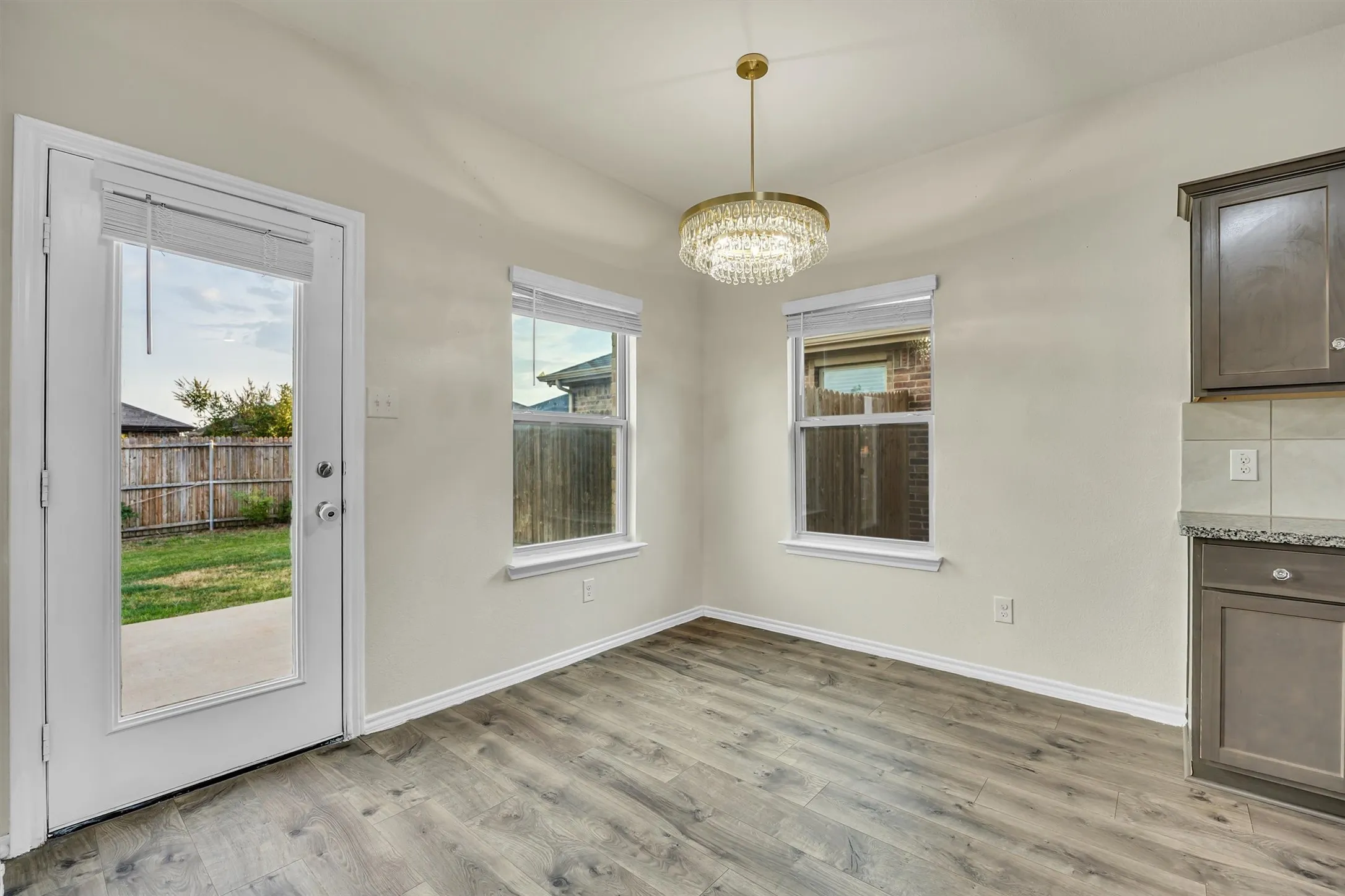 Wood-finish flooring, two large windows, and a glass-paneled exterior door
