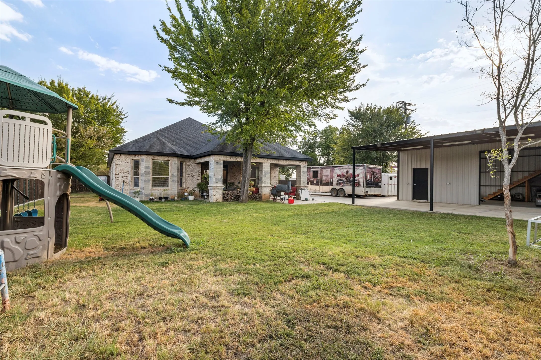 Expansive lawn area with a mature shade tree