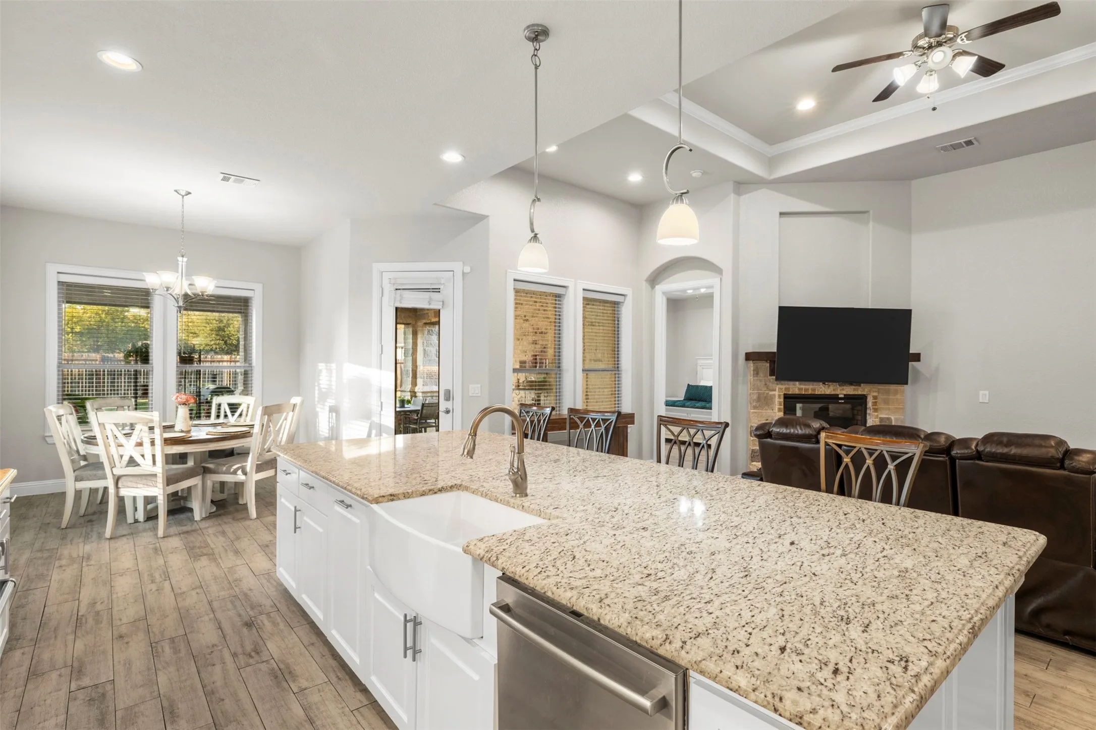Kitchen island with granite countertops, a farmhouse sink, and pendant lighting