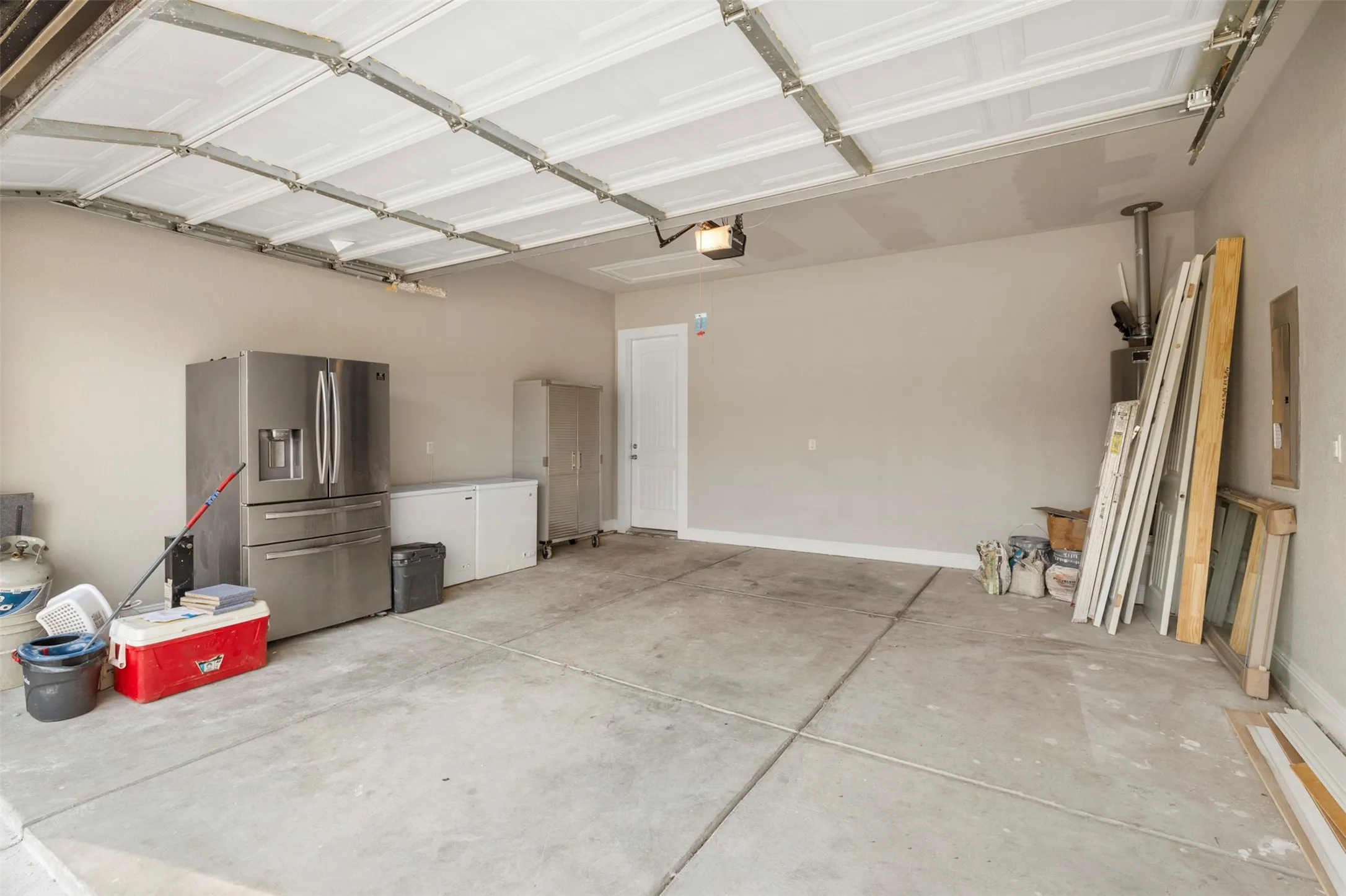 Expansive garage space with concrete flooring and paneled garage door