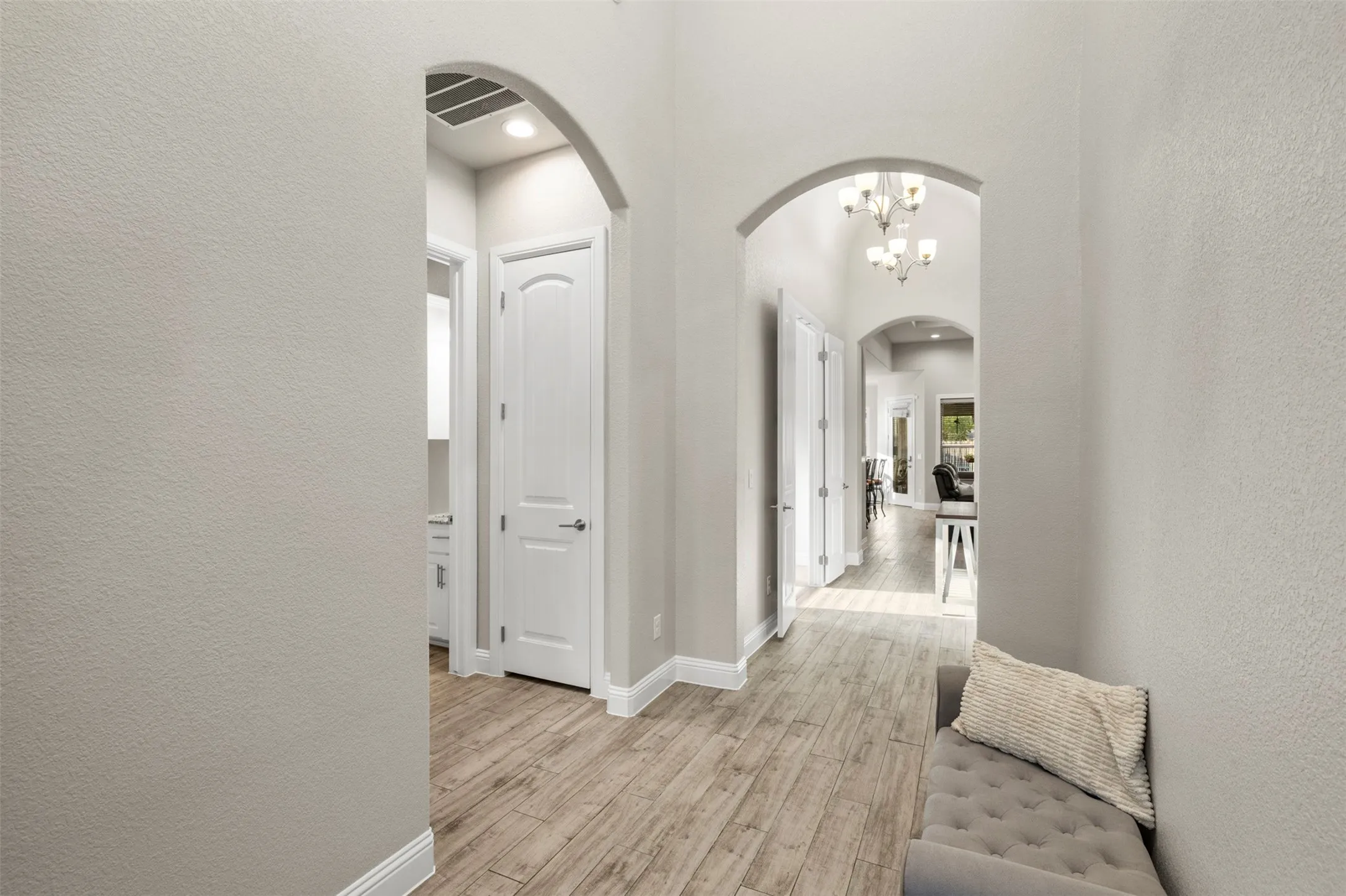 Archways with recessed lighting, wood-finish flooring, and white trim