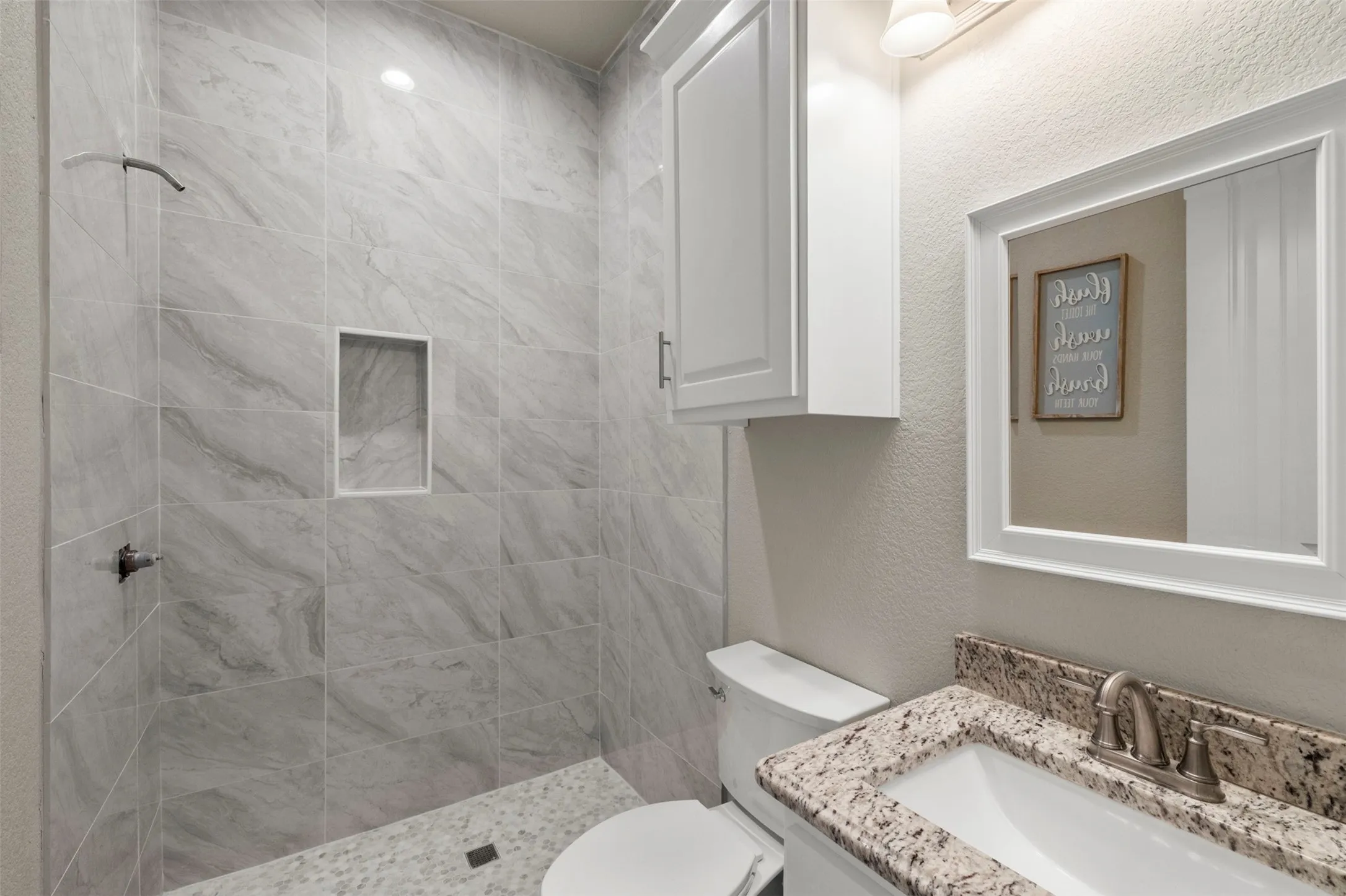 Tiled shower with an integrated niche and pebble flooring