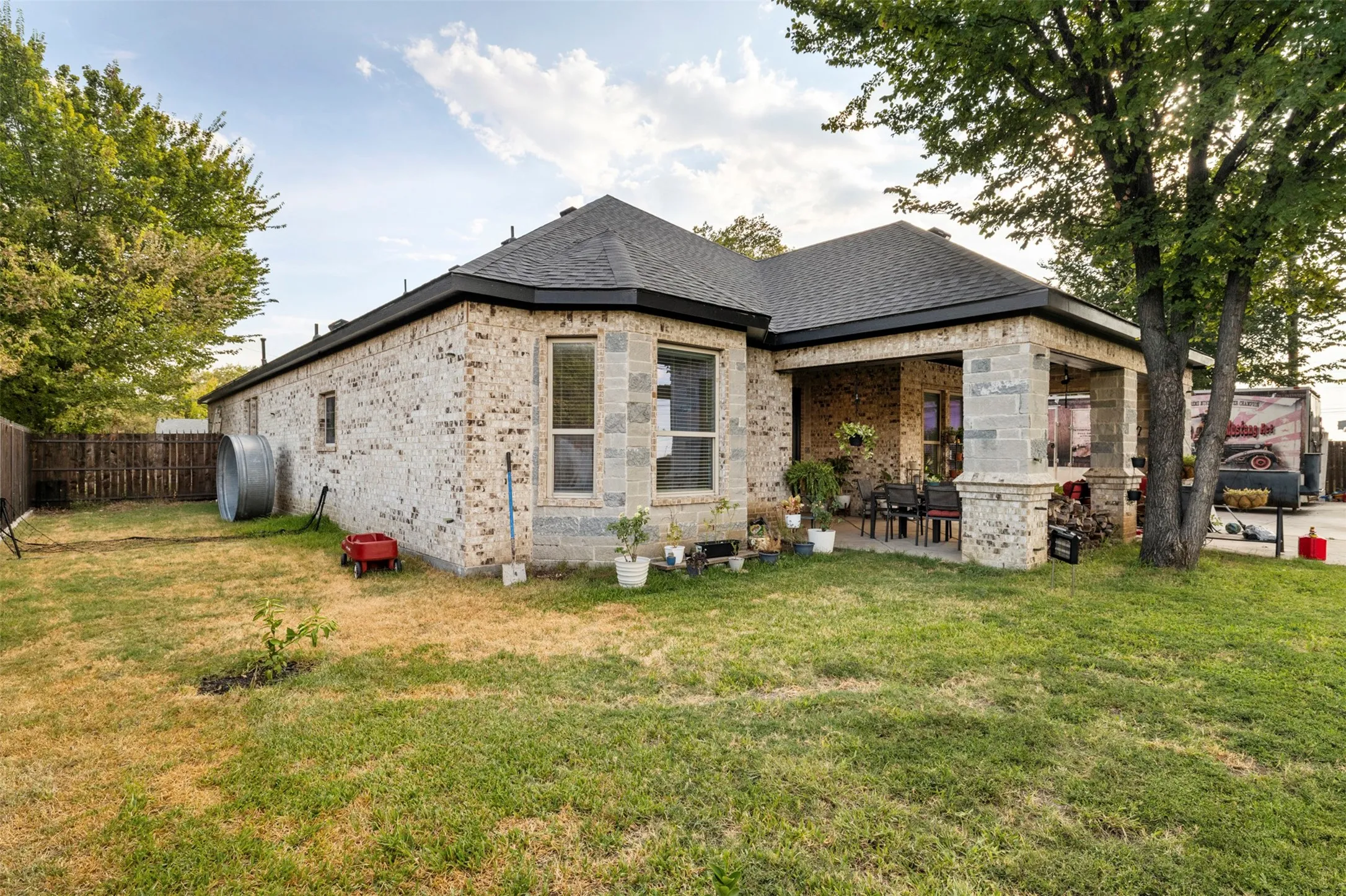 Brick exterior with stone accents, covered patio, and fenced yard