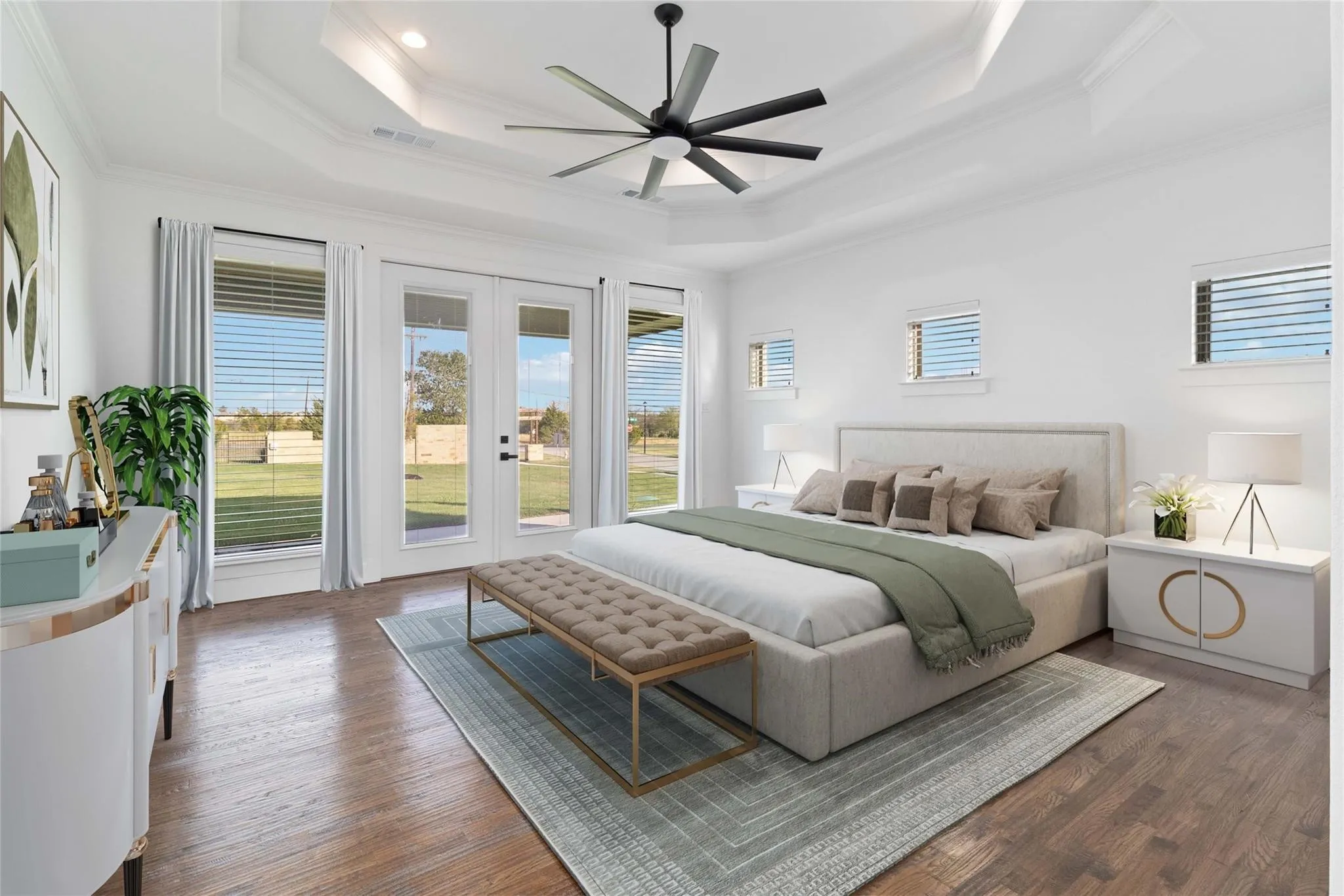 Tray ceiling with a ceiling fan, wood-finish flooring, multiple windows with blinds, and double French doors opening to an outdoor area