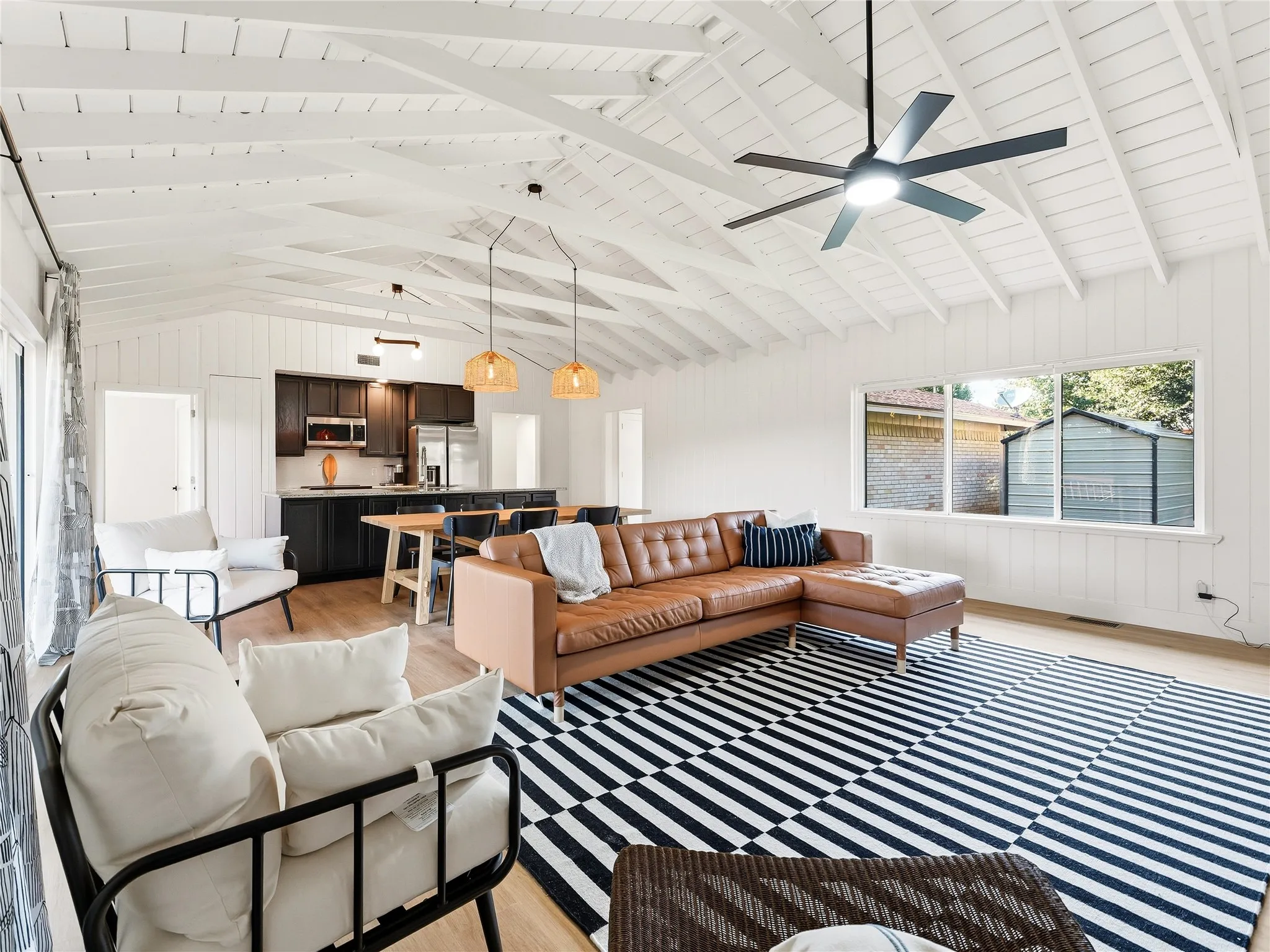 Vaulted ceiling with exposed beams, wood-finish flooring, recessed lighting, and a modern ceiling fan