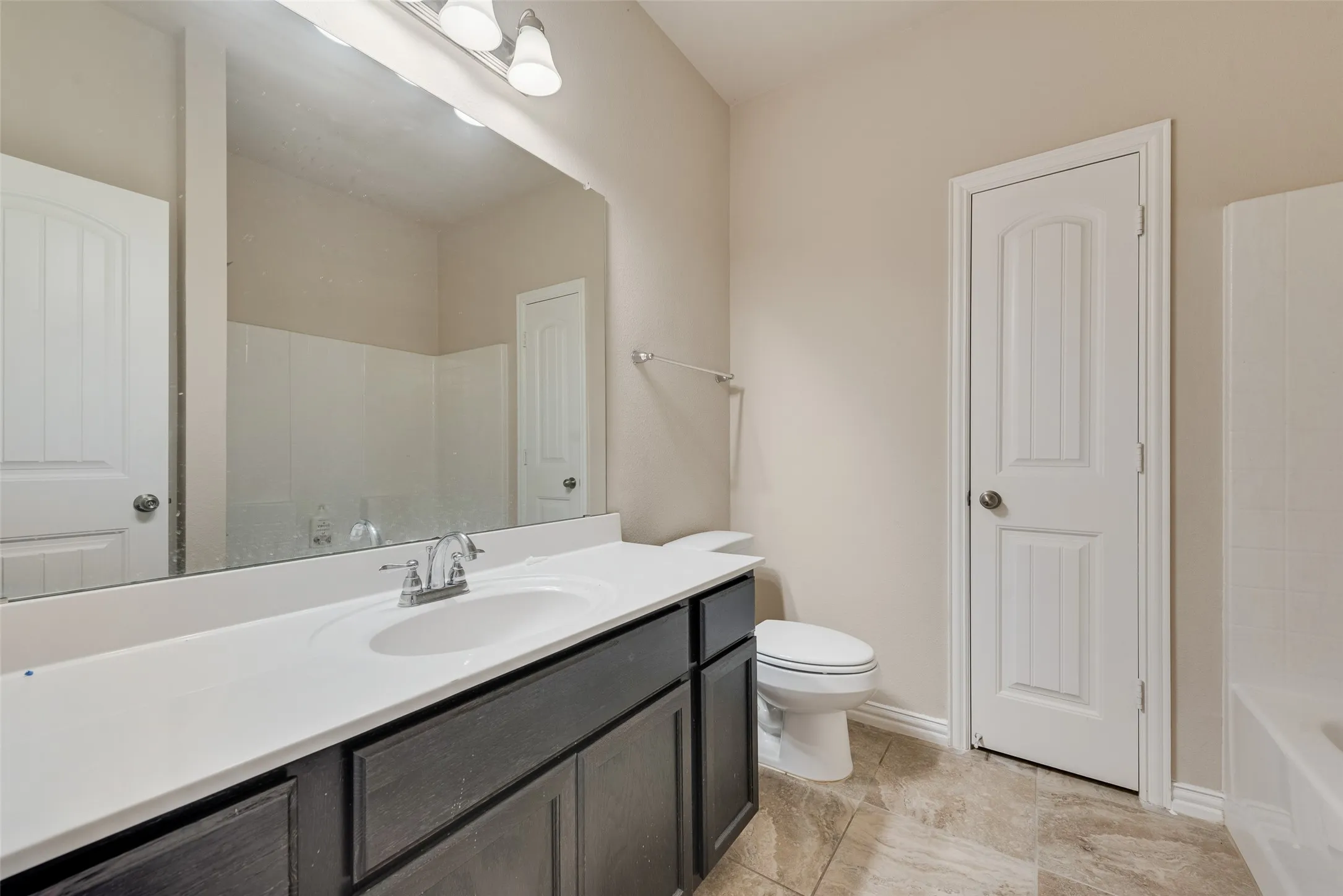Neutral wall color complemented by light-toned floor tiling