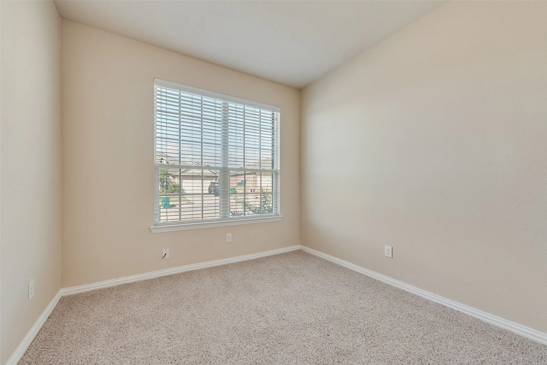 Neutral-toned walls complement the light-colored carpet flooring