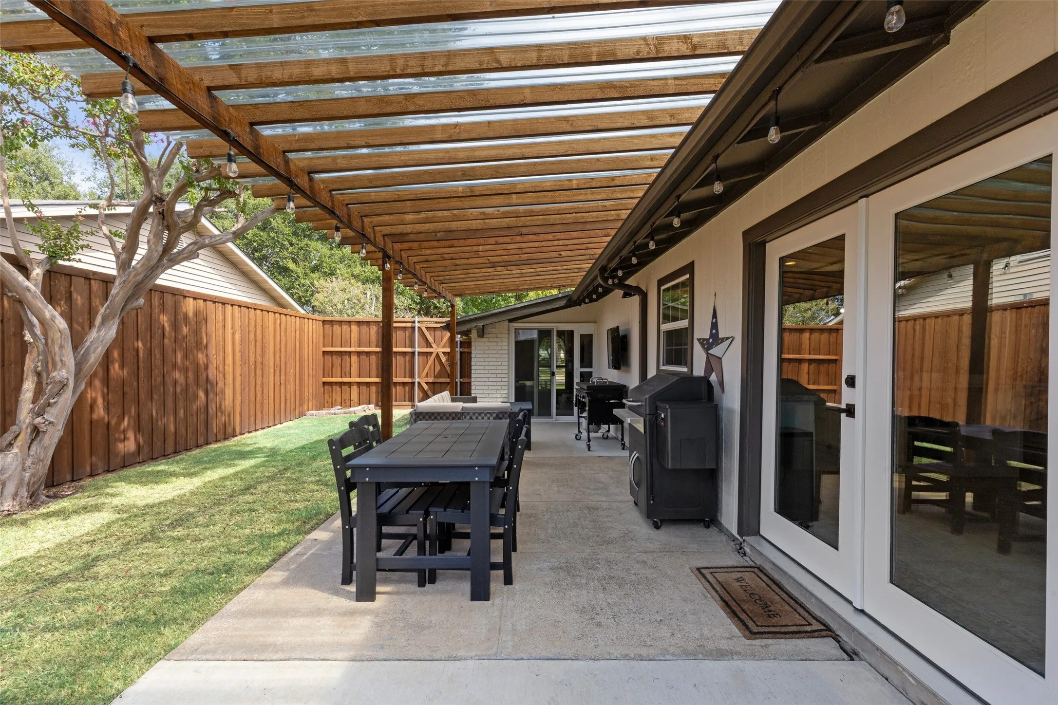 String lights and an extended, pergola-covered patio turn the backyard into a second living room for Texas evenings.