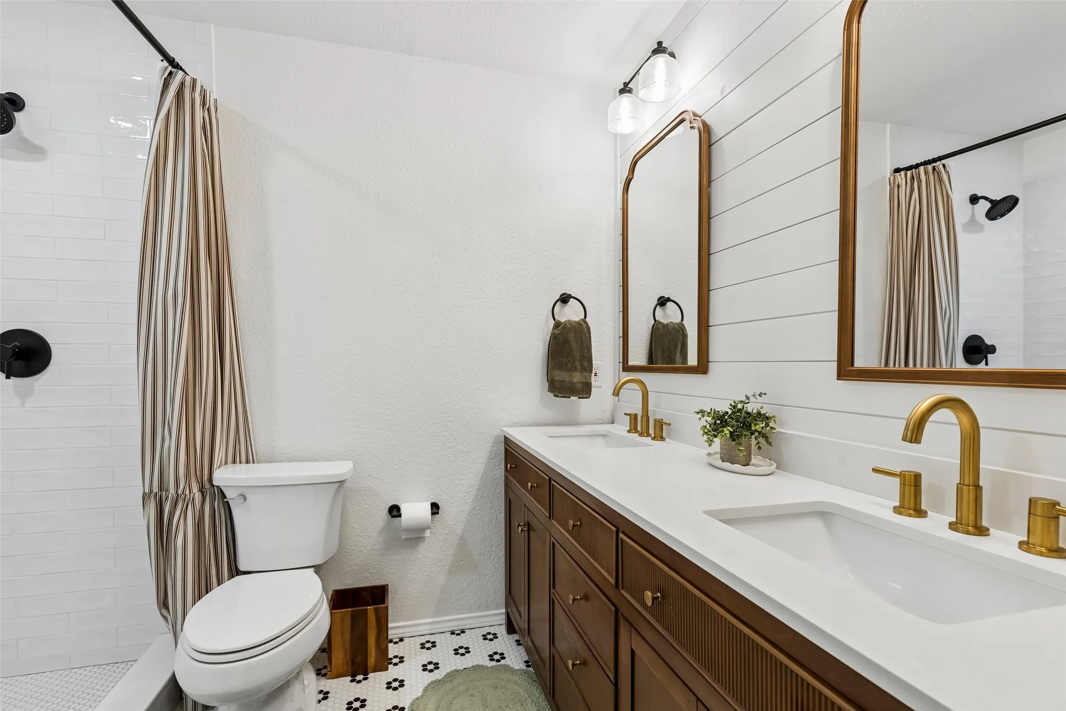The hall bath's tub-and-shower combo, finished in white subway tile, serves both secondary bedrooms.