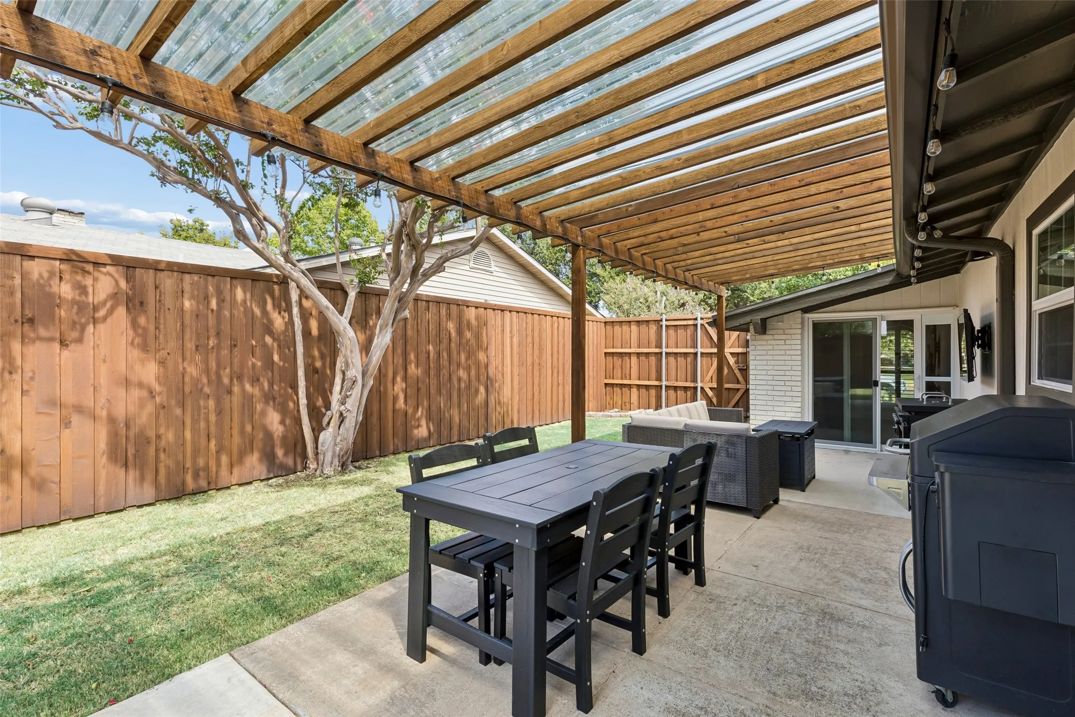 Mature trees shade a backyard built for year-round use, patio cover included.