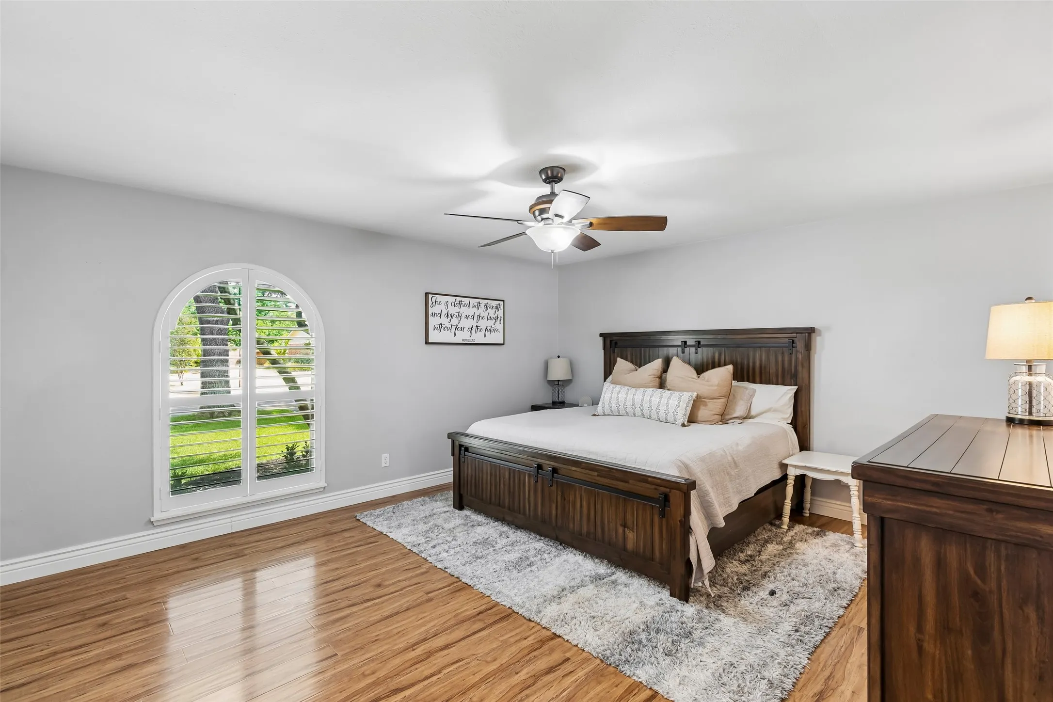 The primary bedroom's arched, shuttered window brings in soft light without sacrificing privacy.