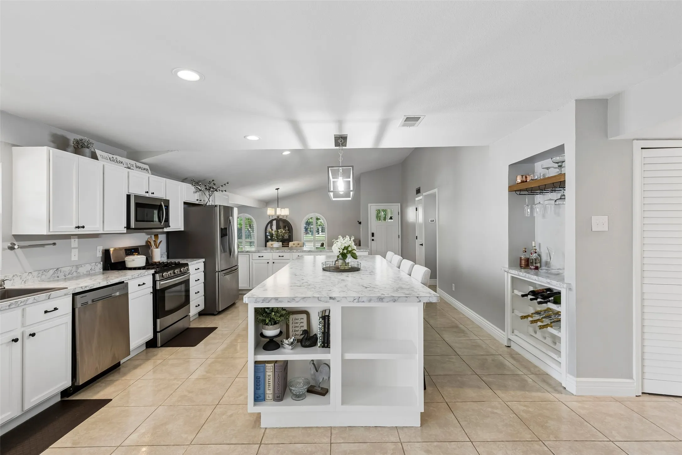 A custom bar area with a built-in wine glass rack turns the kitchen's edge into its own entertaining station.