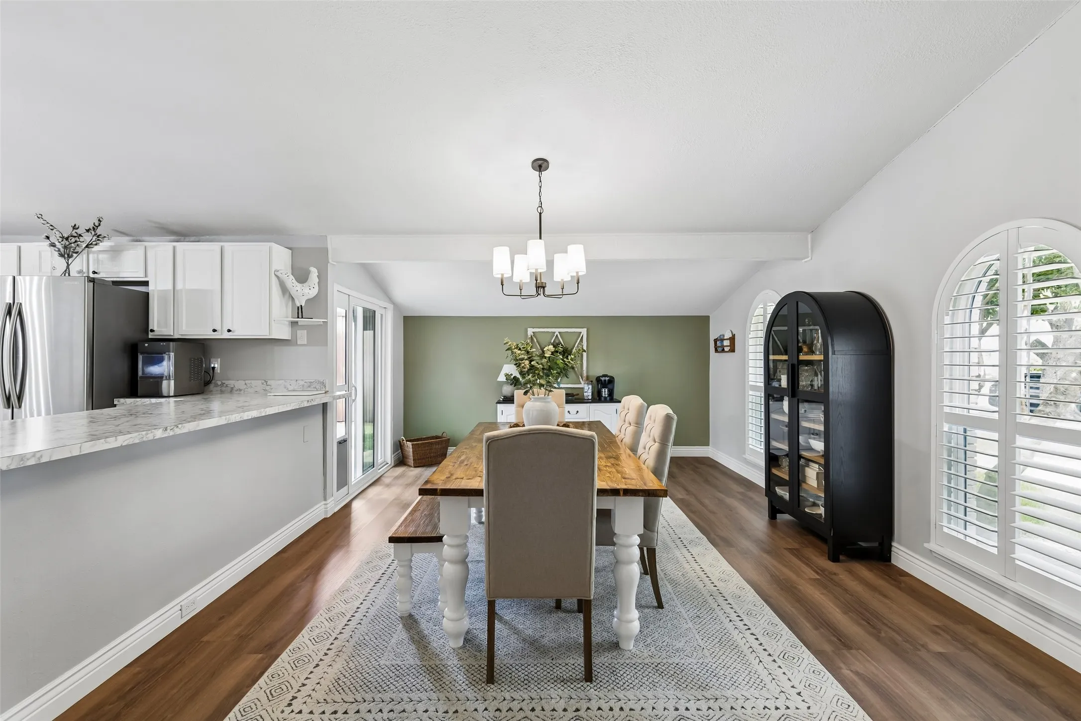 Arched, shuttered windows dress up the dining room within the home's open floor plan.