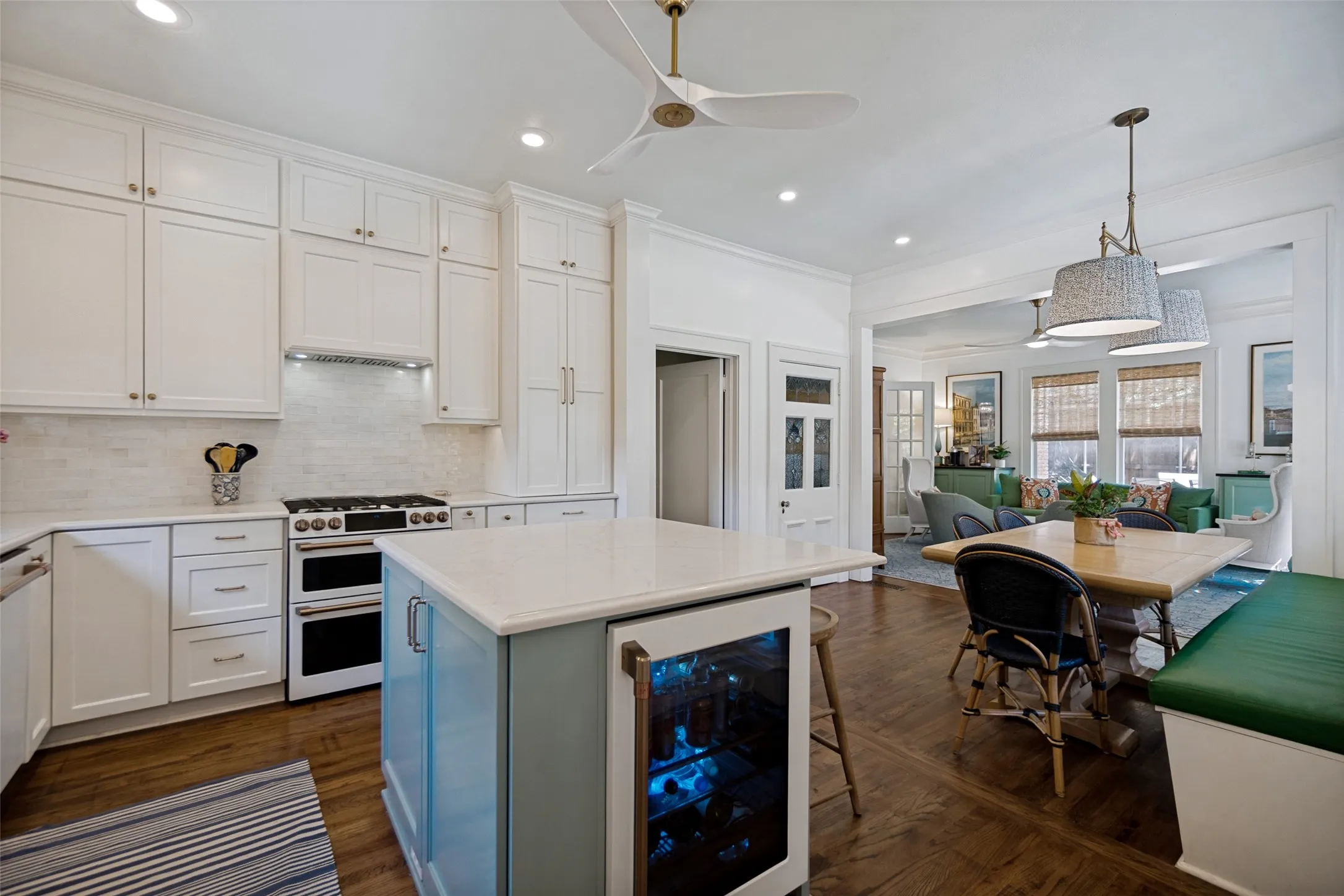 Gourmet kitchen featuring a double oven range, white shaker cabinetry, white subway tile backsplash, and a center island with integrated beverage refrigerator