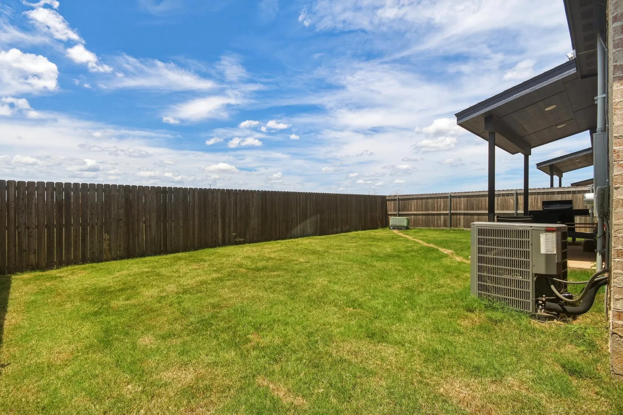 Expansive lawn area with a wood privacy fence