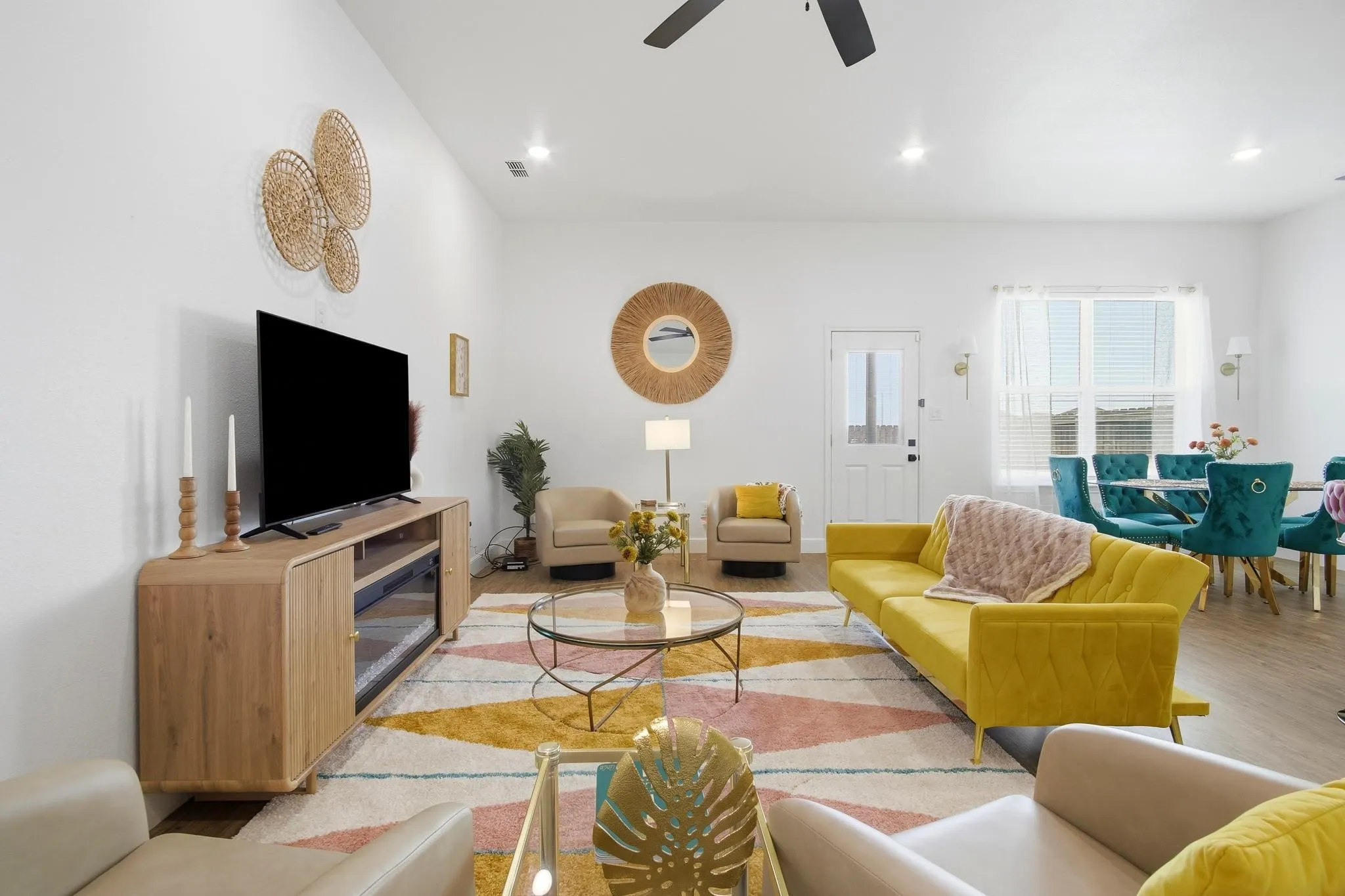 Open-concept living space with light wood-finish flooring, vaulted ceilings, recessed lighting, and a ceiling fan