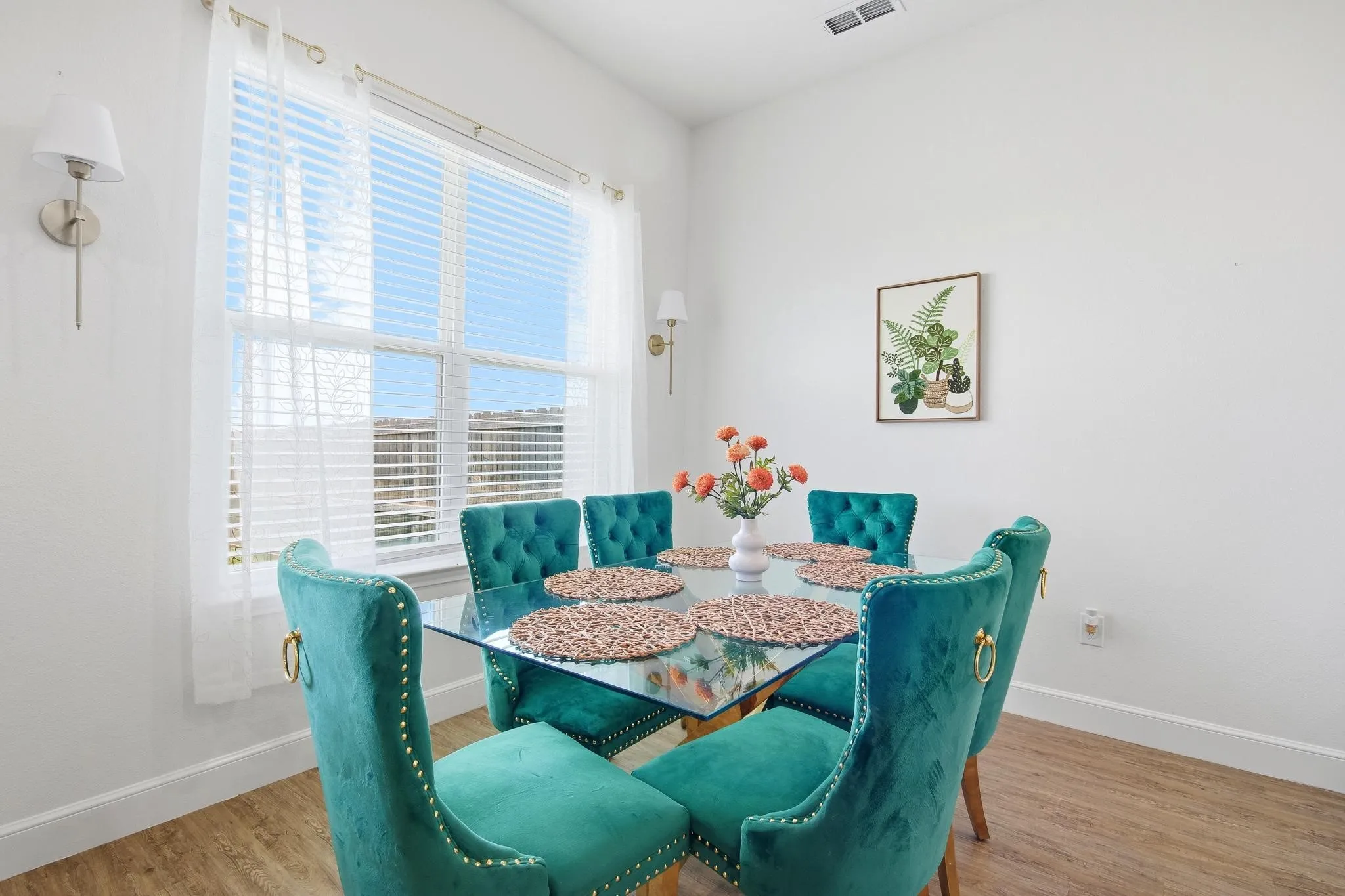 Large window with horizontal blinds, wall-mounted sconce lighting, and wood-finish flooring