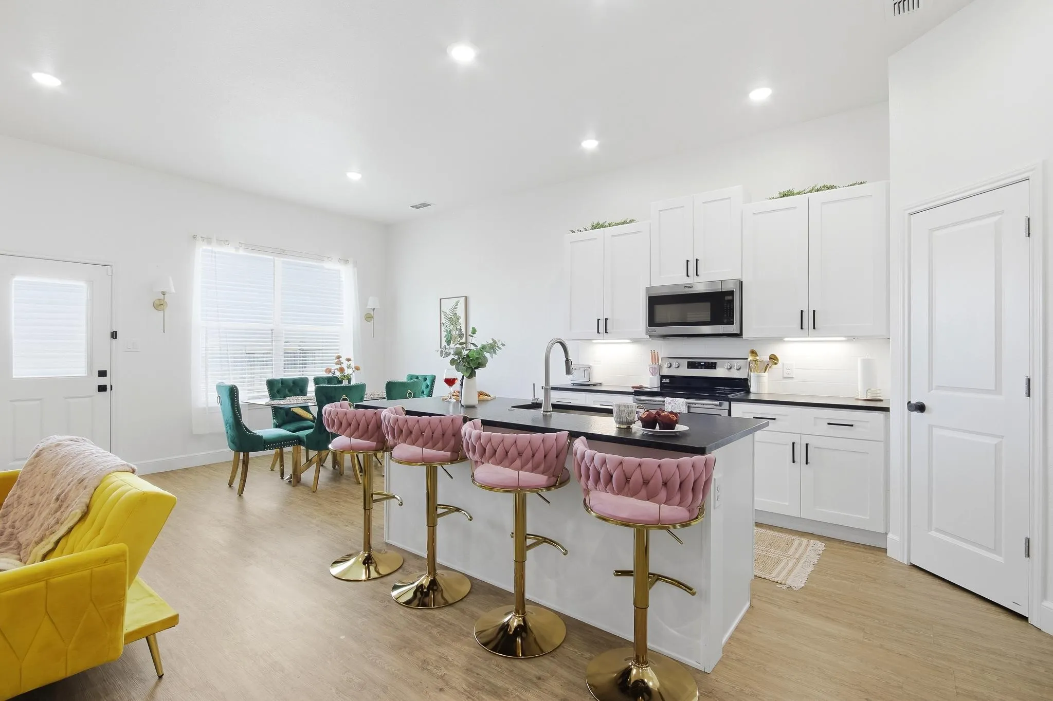 Open-concept living area featuring wood-finish flooring, recessed lighting, and a kitchen island with seating