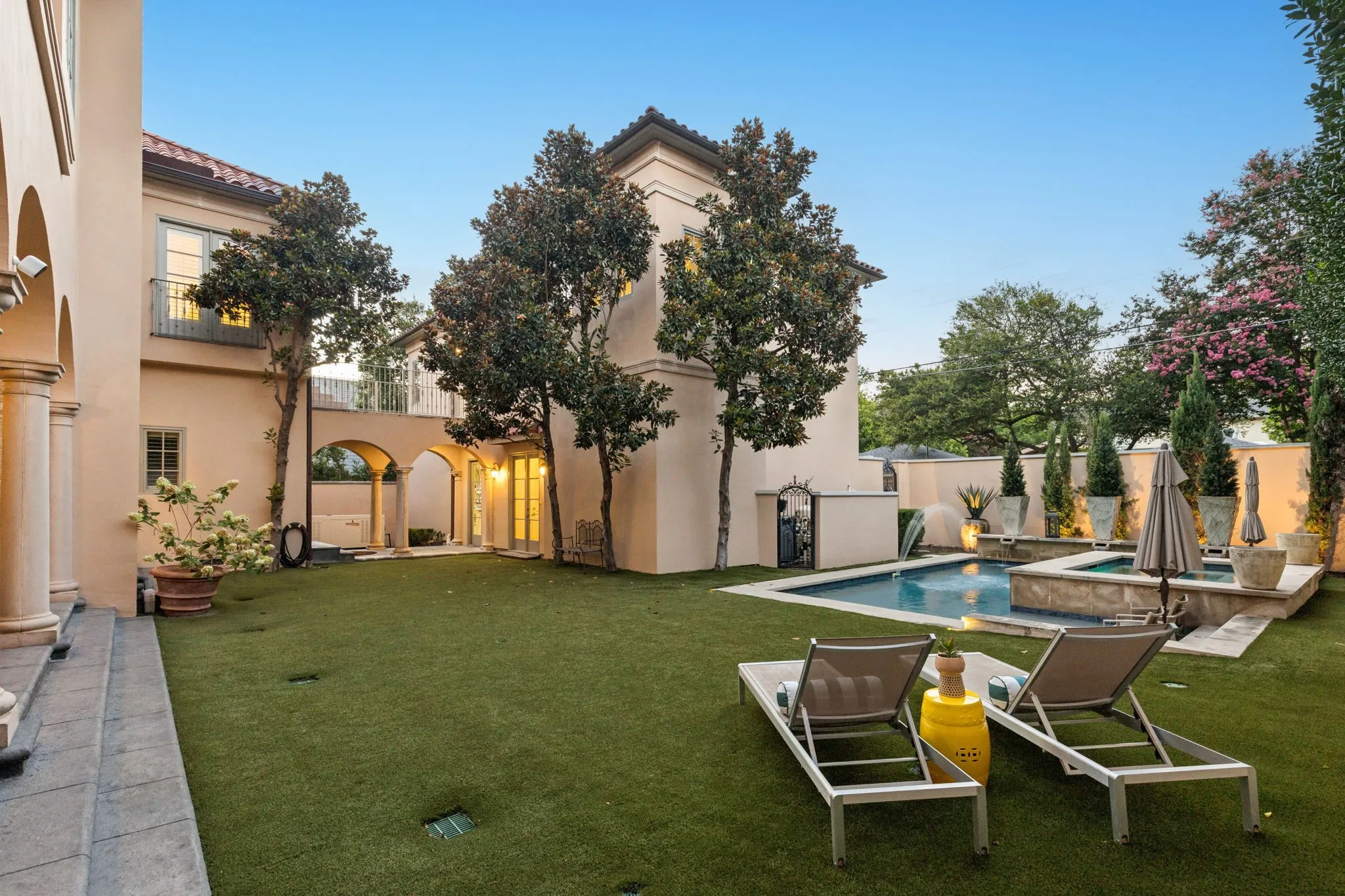 Turfed back yard with covered patio and fireplace.