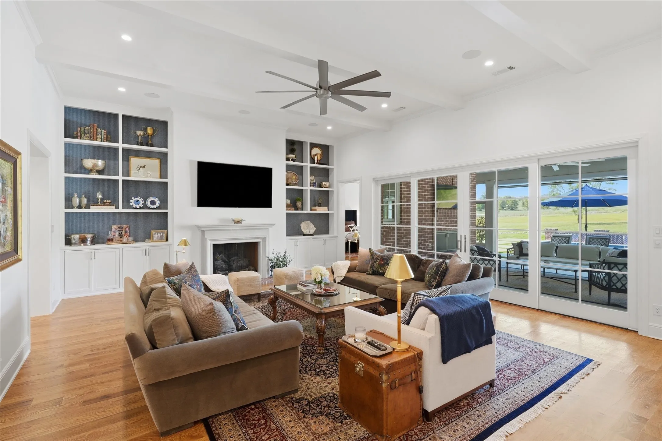 The living room offers white oak wood floors and brick fireplace with stone mantle. The wood sliding doors offer a seamless transition to the outdoor living space.