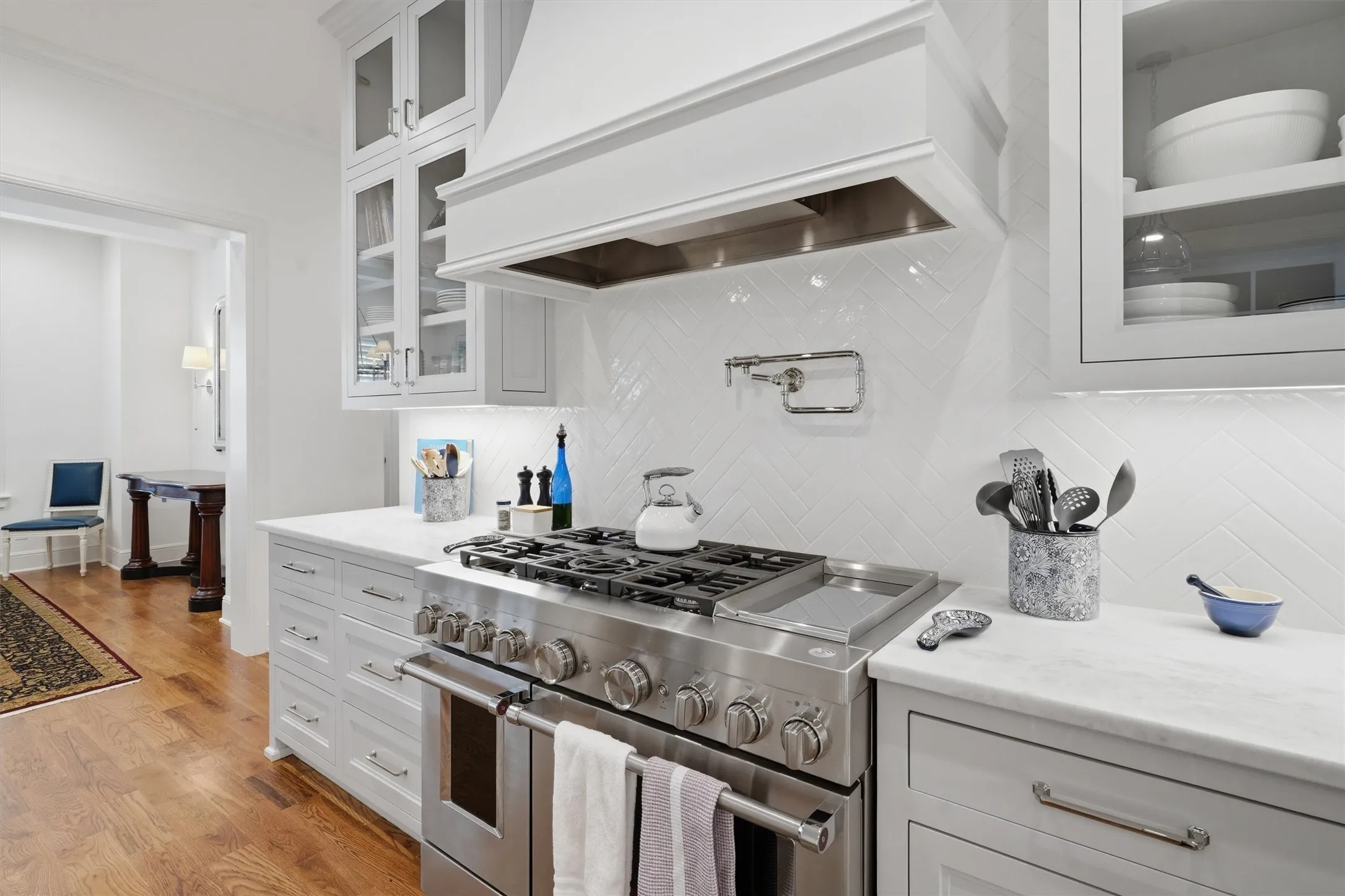 The kitchen has a double oven, six burner gas stove with pot filler.