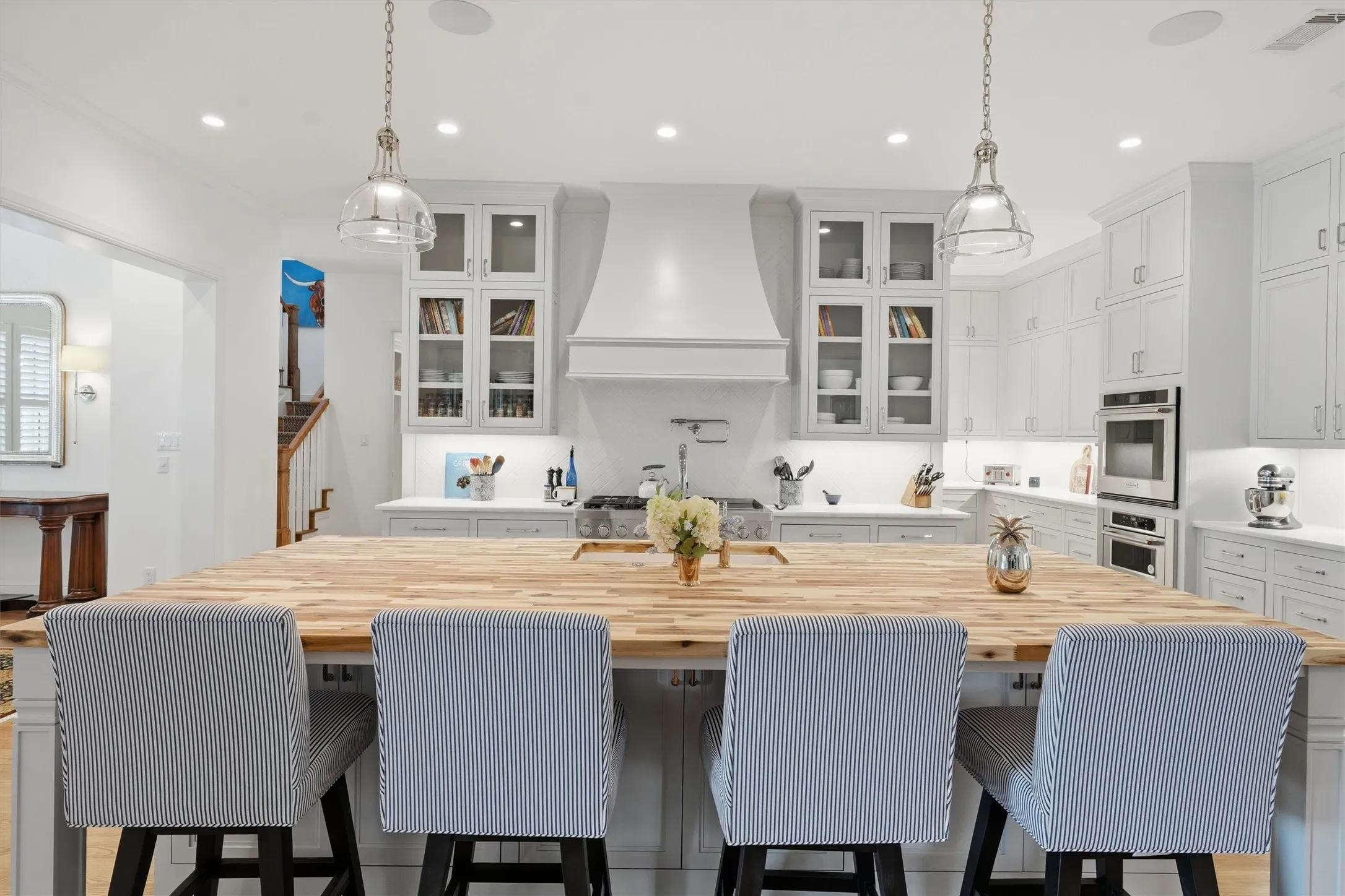 The chefs kitchen is complete with 3 ovens, a 6-burner gas range, pot filler, Sub-Zero refrigerator and wine fridge, built-in nugget ice maker, 2 dishwashers, a butler pantry, and ample counter space.