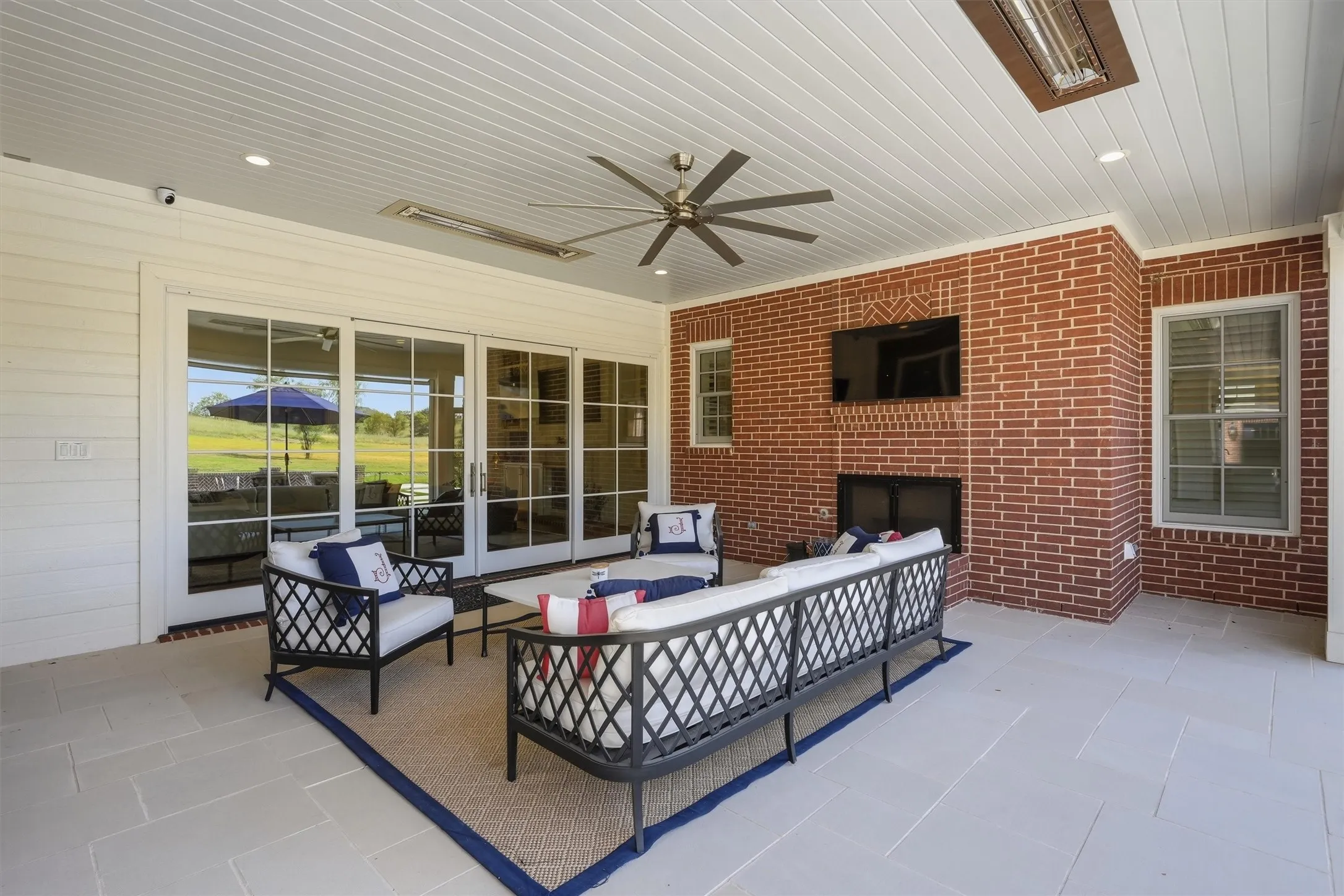 This back patio is the perfect extension of the living area. Slide the beautiful wooden doors open and enjoy an indoor outdoor living space. The fireplace and tv make it a great spot to enjoy your evenings! There are ceiling fans and ceiling heaters. The electric shade is perfect for blocking the sun!