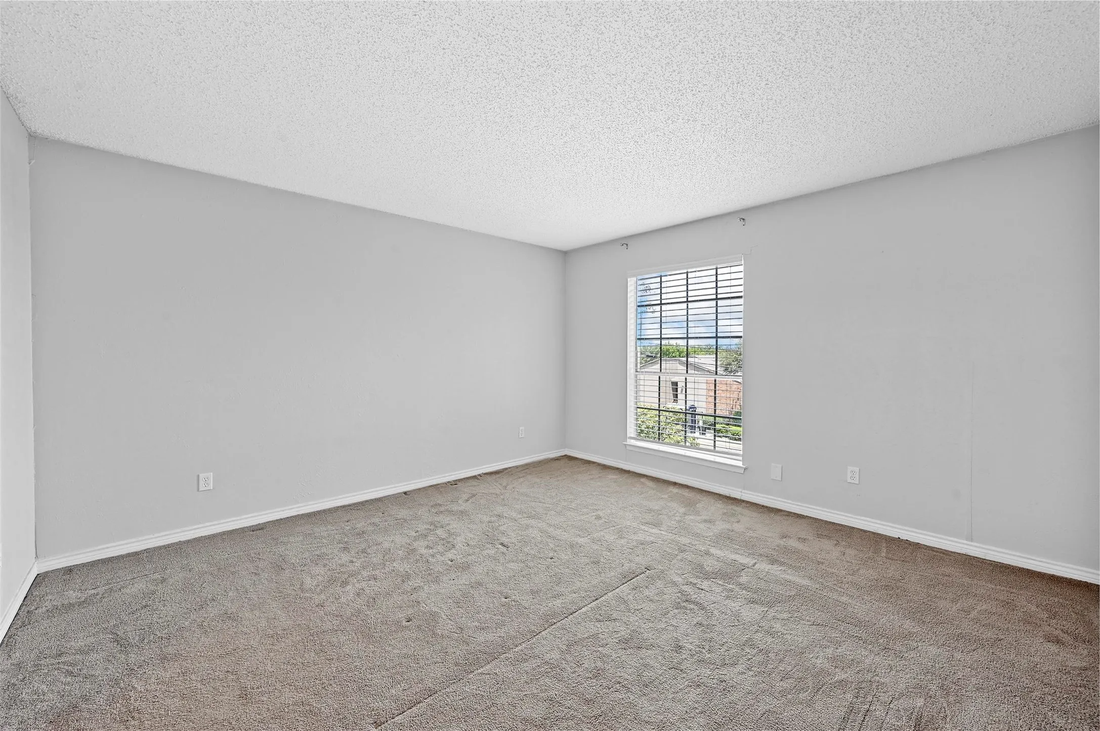 Carpeted spare room featuring a textured ceiling