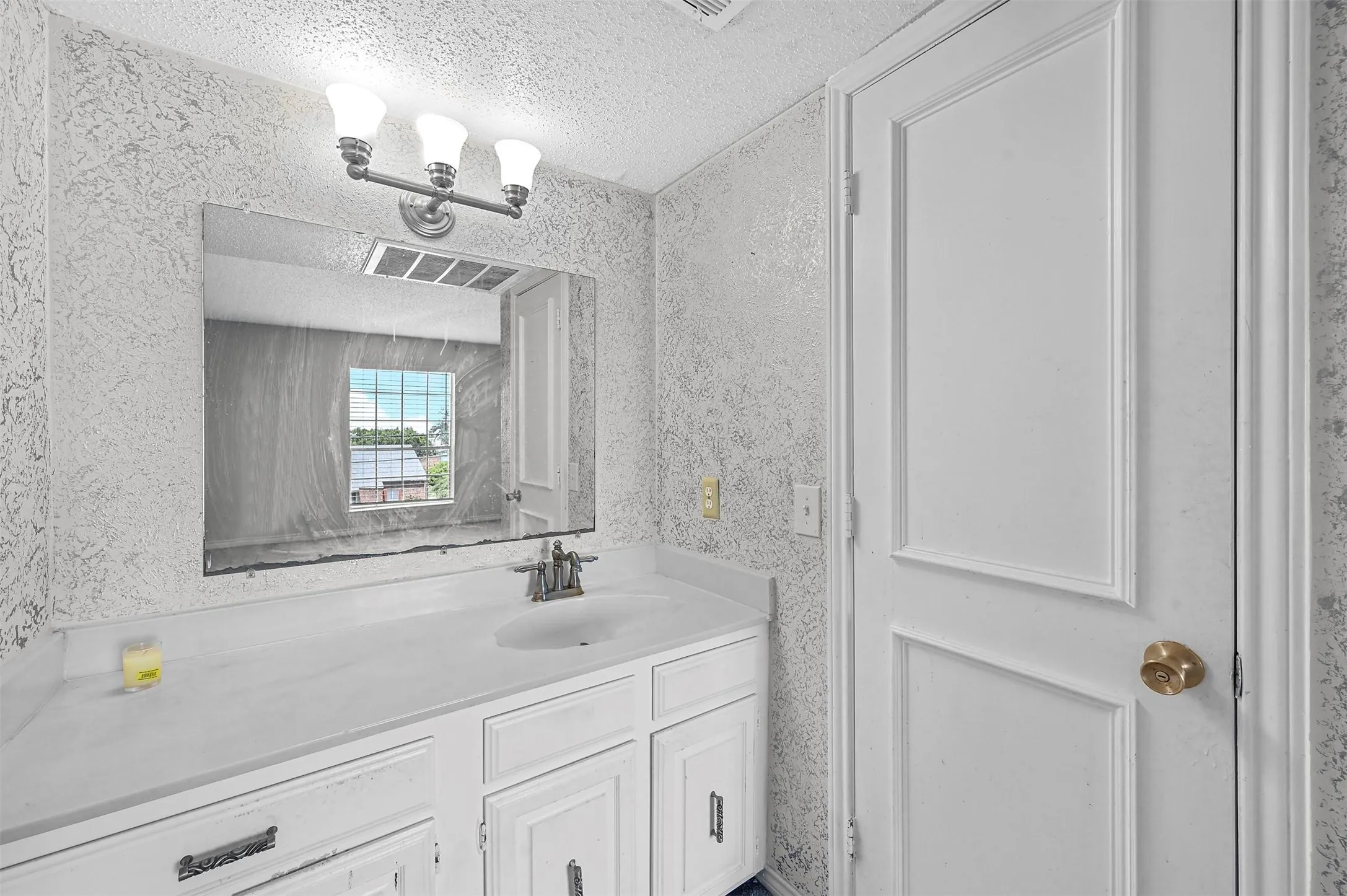 Bathroom with vanity and a textured ceiling