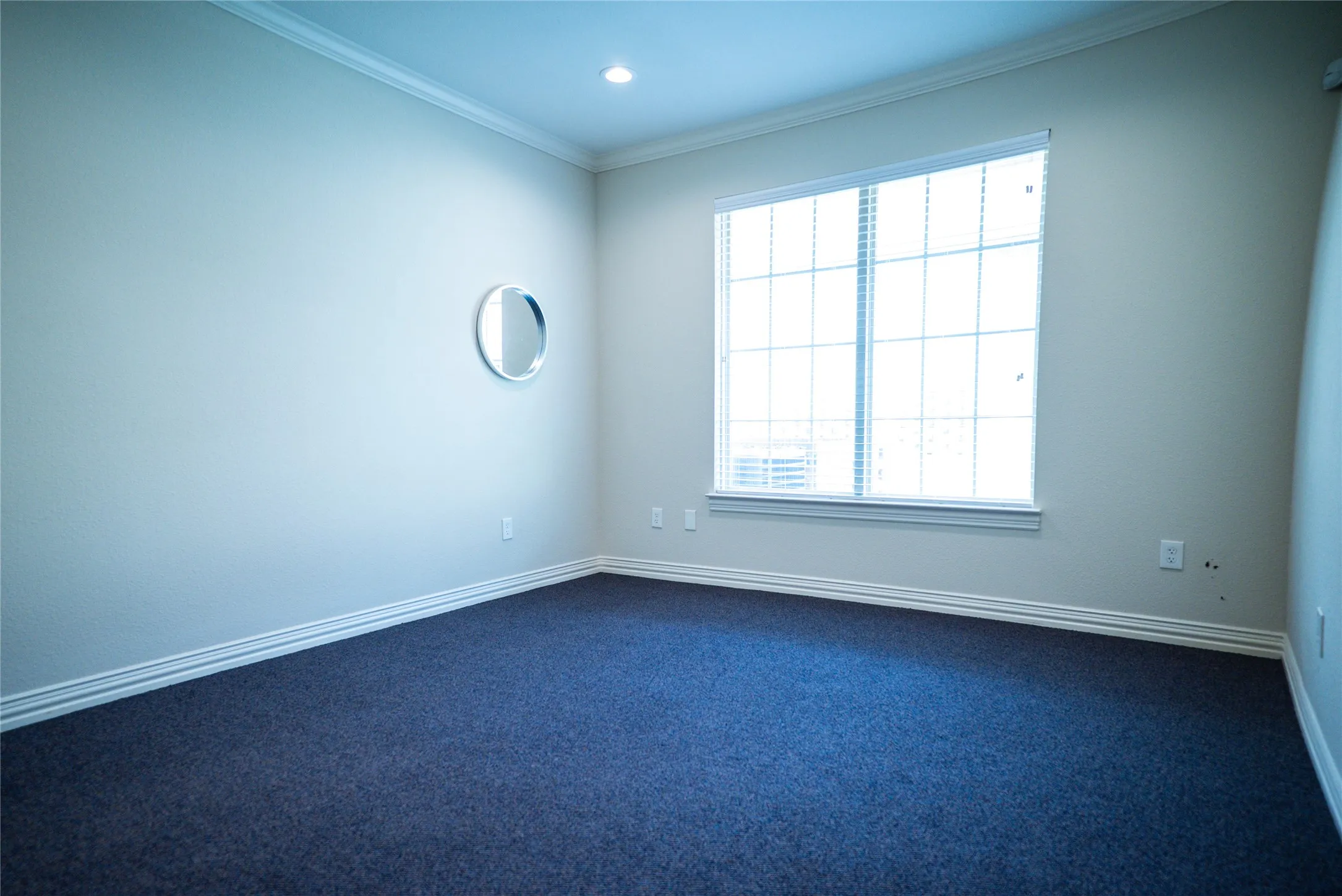 Recessed lighting, crown molding, white trim, and dark blue carpeting