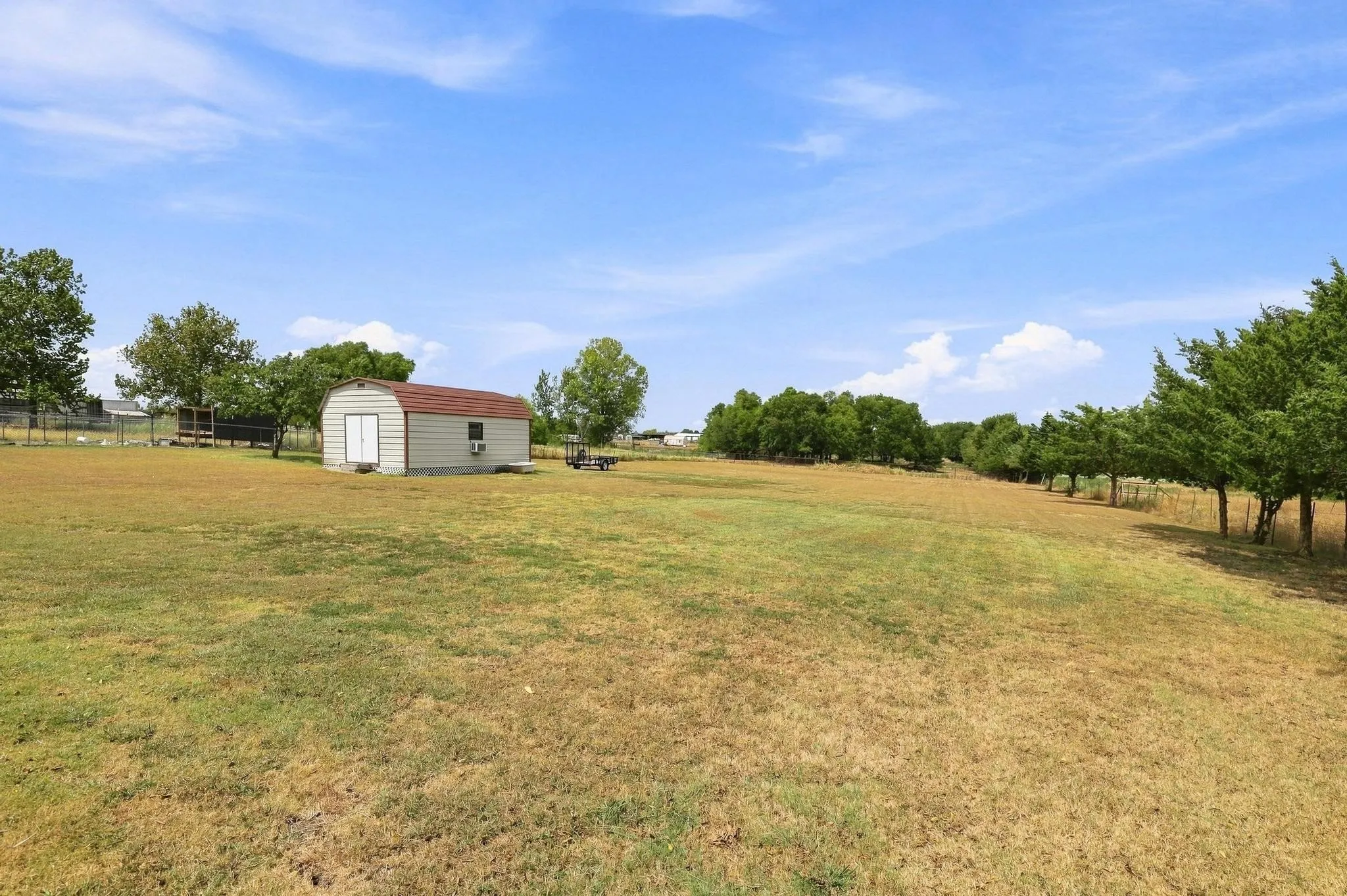 Expansive outdoor space featuring a detached workshop with electric and AC window unit