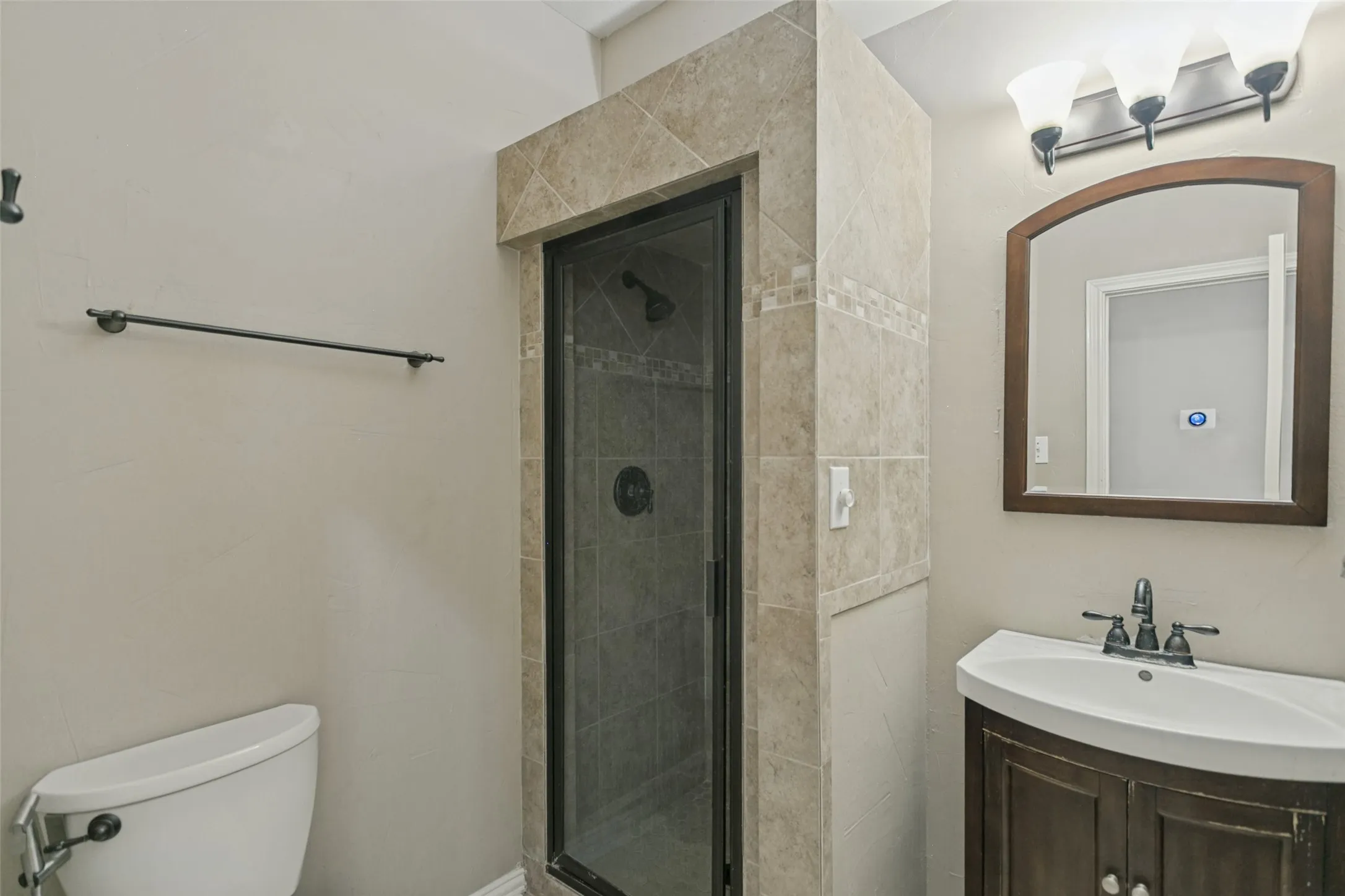 Tiled shower enclosure with a dark-framed glass door