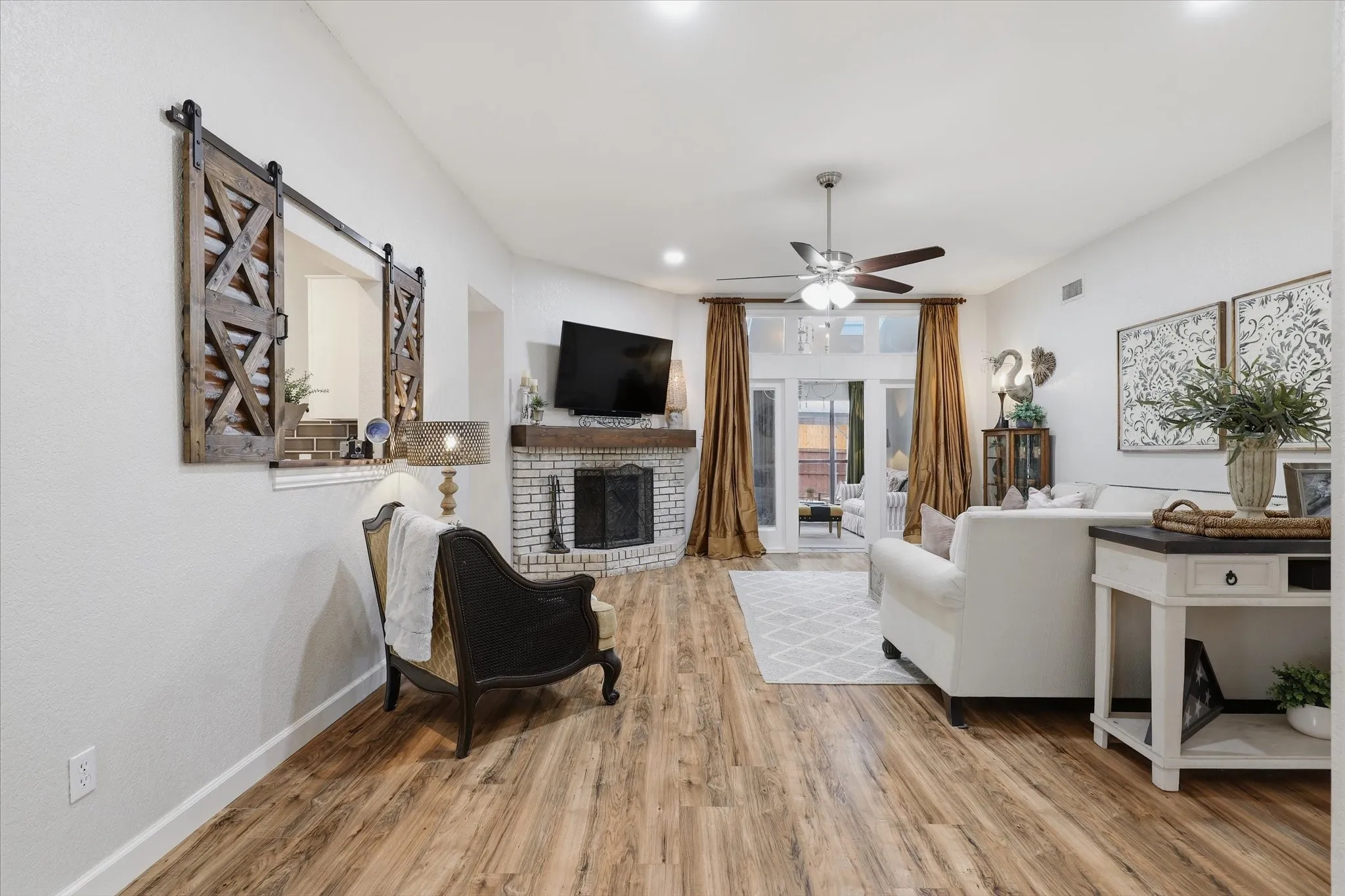Spacious family room features wood-like flooring, a brick fireplace and an easy flow into the light-filled flex space.