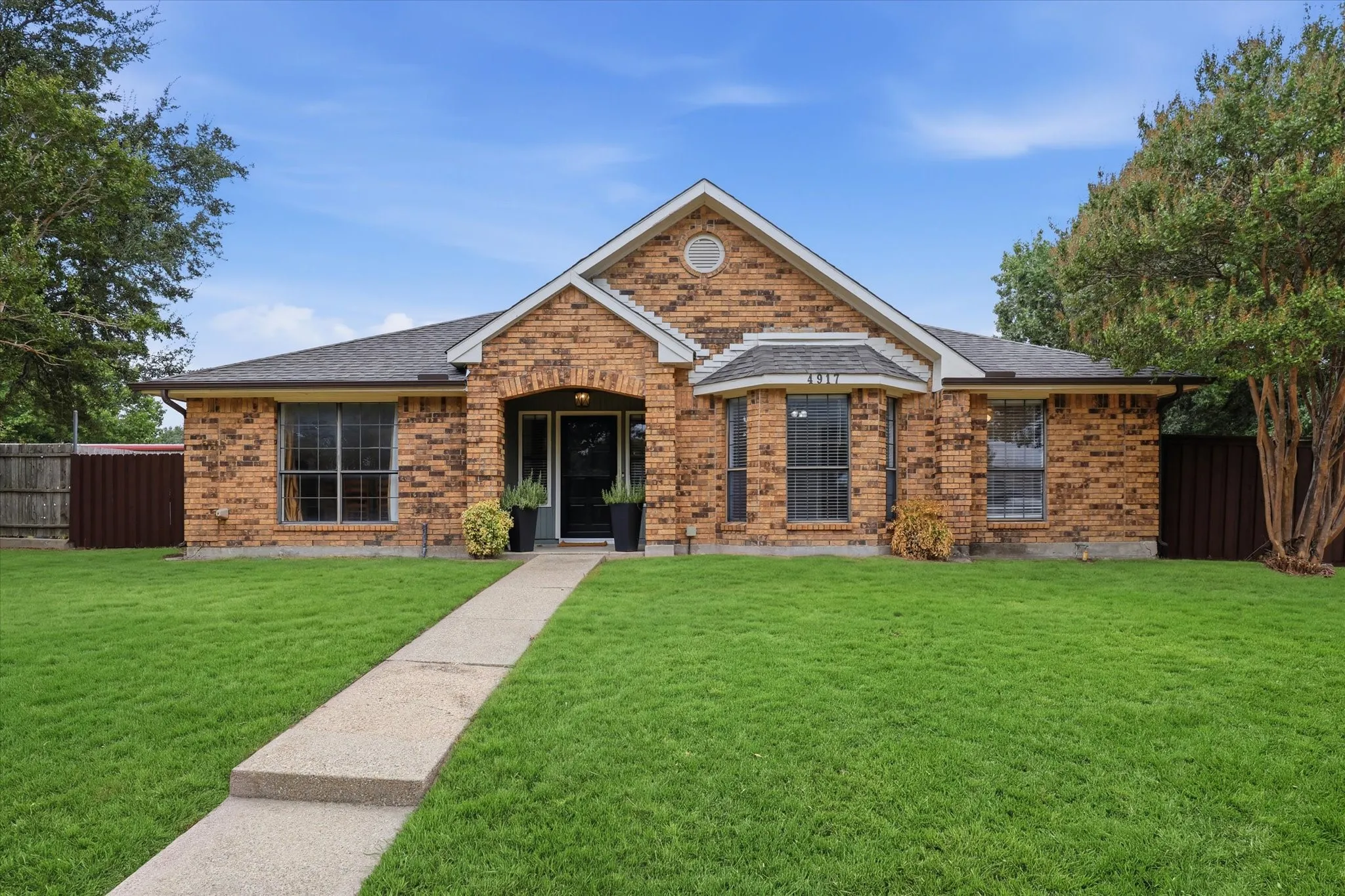 Classic brick exterior framed by mature trees.