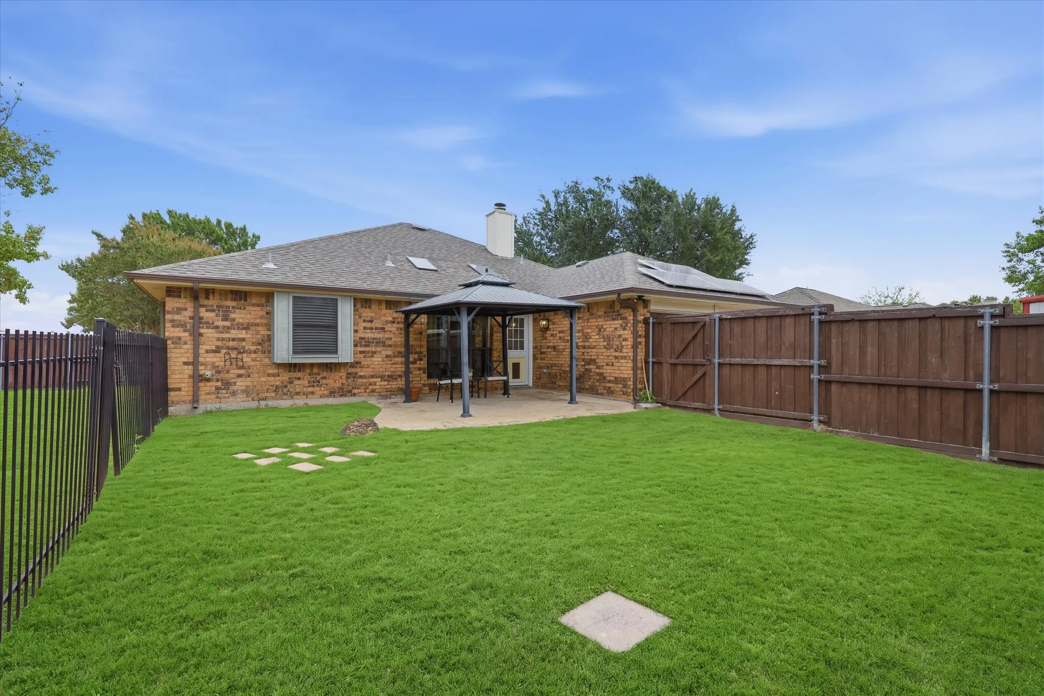 Spacious fenced backyard provides plenty of room for play, pets and outdoor entertaining, with a covered patio just off the home.