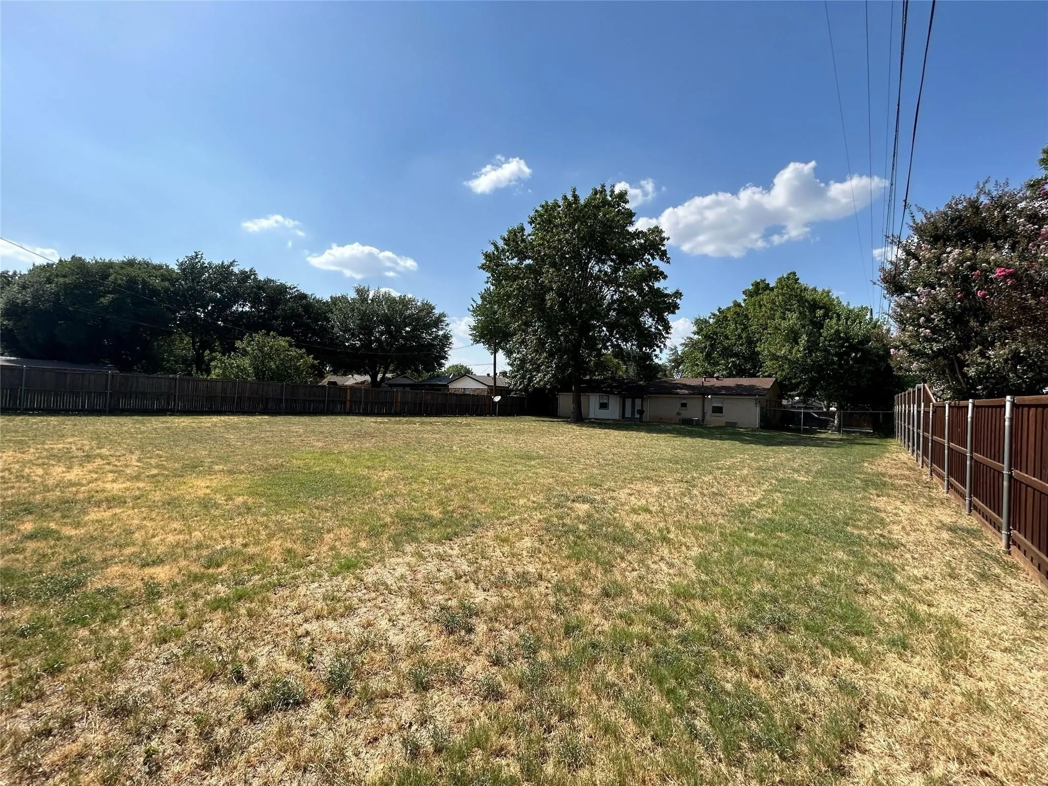 Expansive lot featuring a fenced perimeter and mature trees