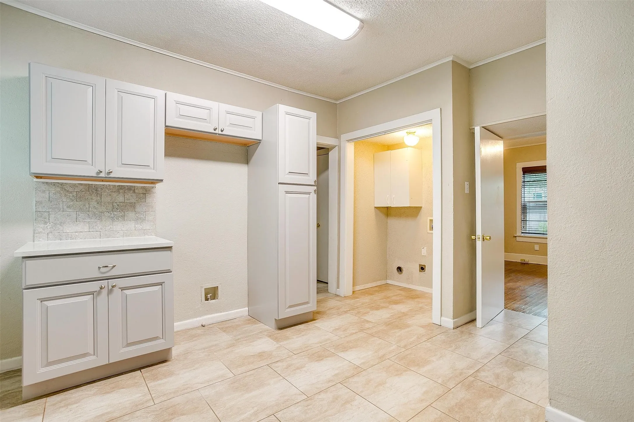 Cabinets surrounding refrigerator and a subway tile backsplash