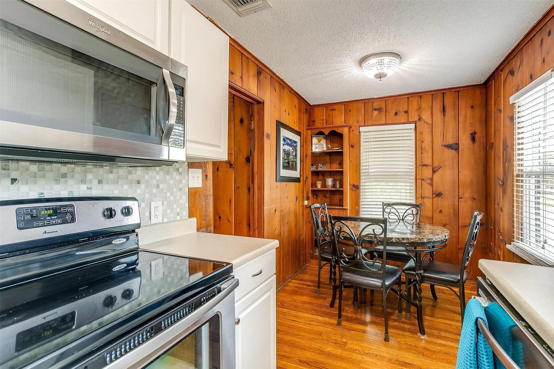 Galley kitchen w/ stainless steel appliances, and a tiled backsplash