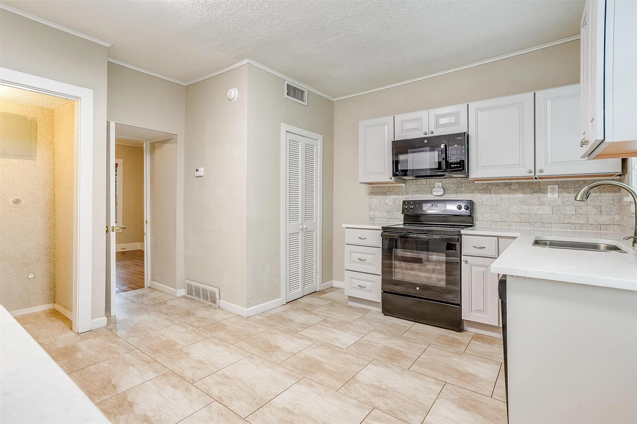 Kitchen featuring tile flooring opens to the downstairs master.