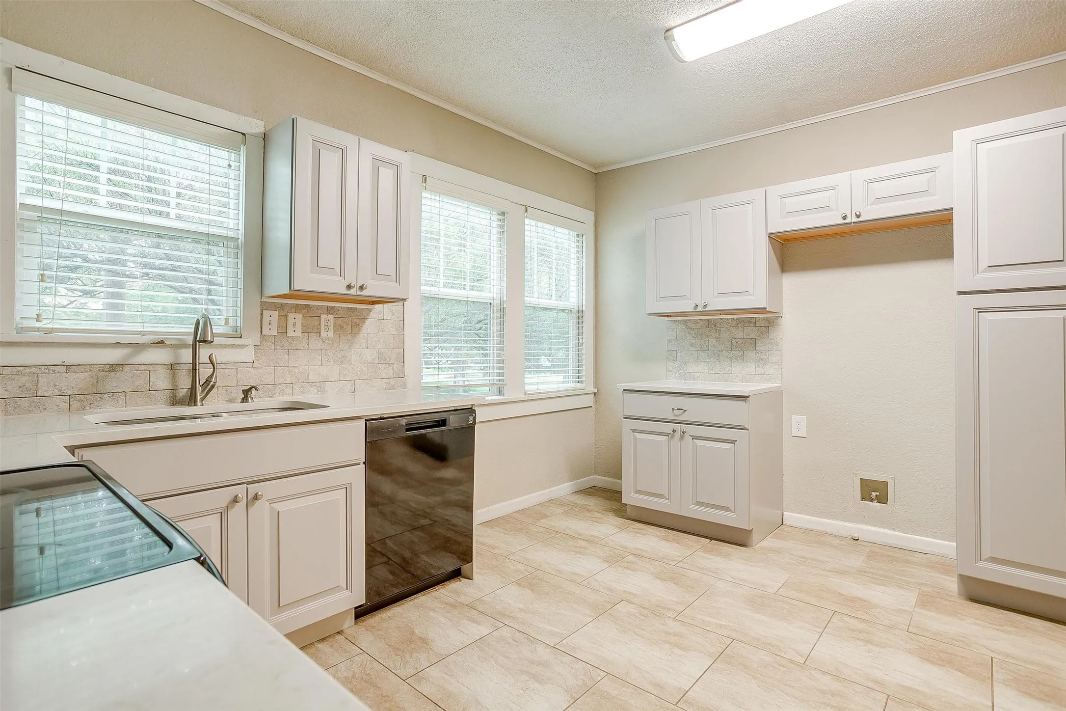 White shaker-style cabinetry, stainless steel sink with gooseneck faucet